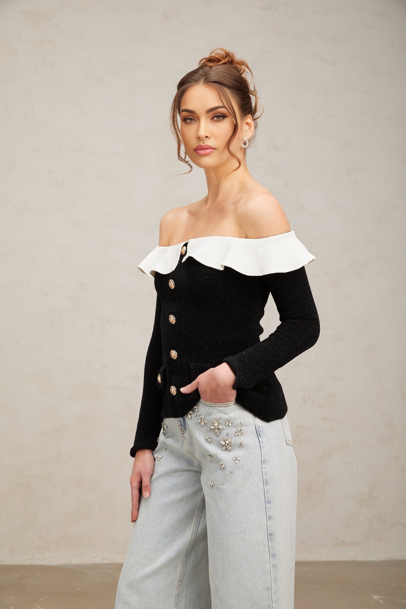 Woman wearing black offshoulder top with ruffled neckline