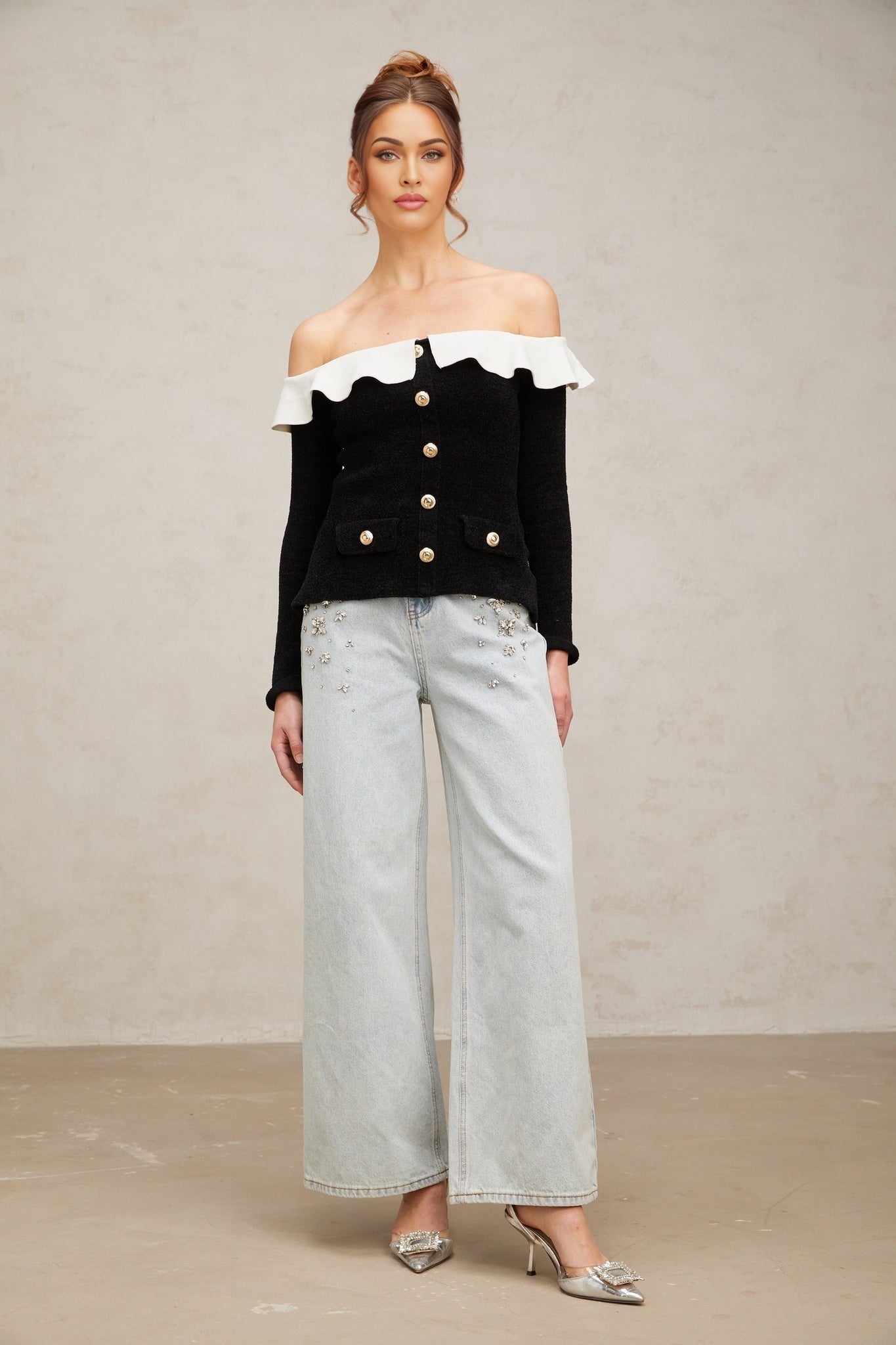 Woman wearing black offshoulder top with ruffled neckline