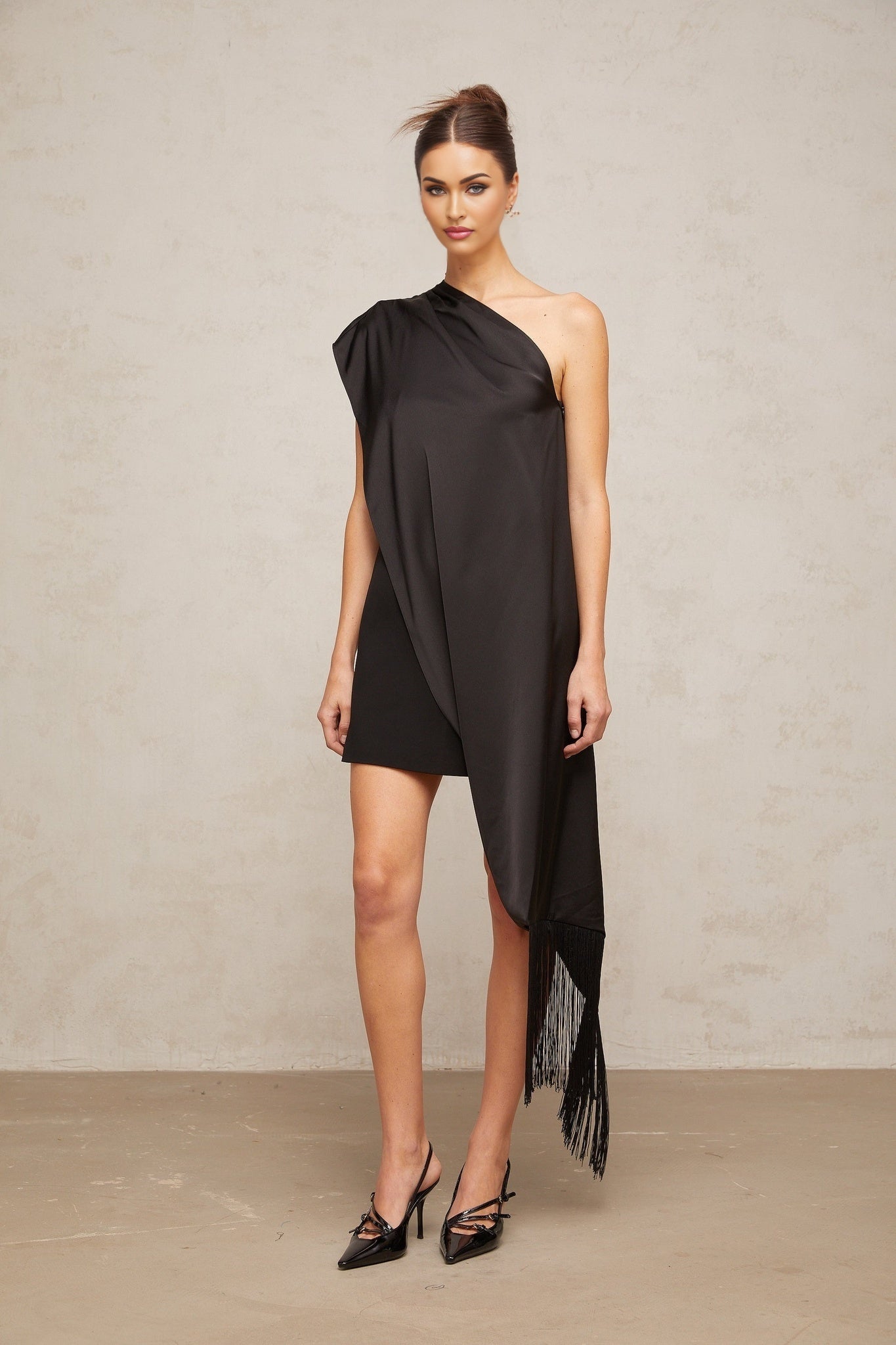 Woman wearing black one shoulder mini dress for Valentines Day occasion