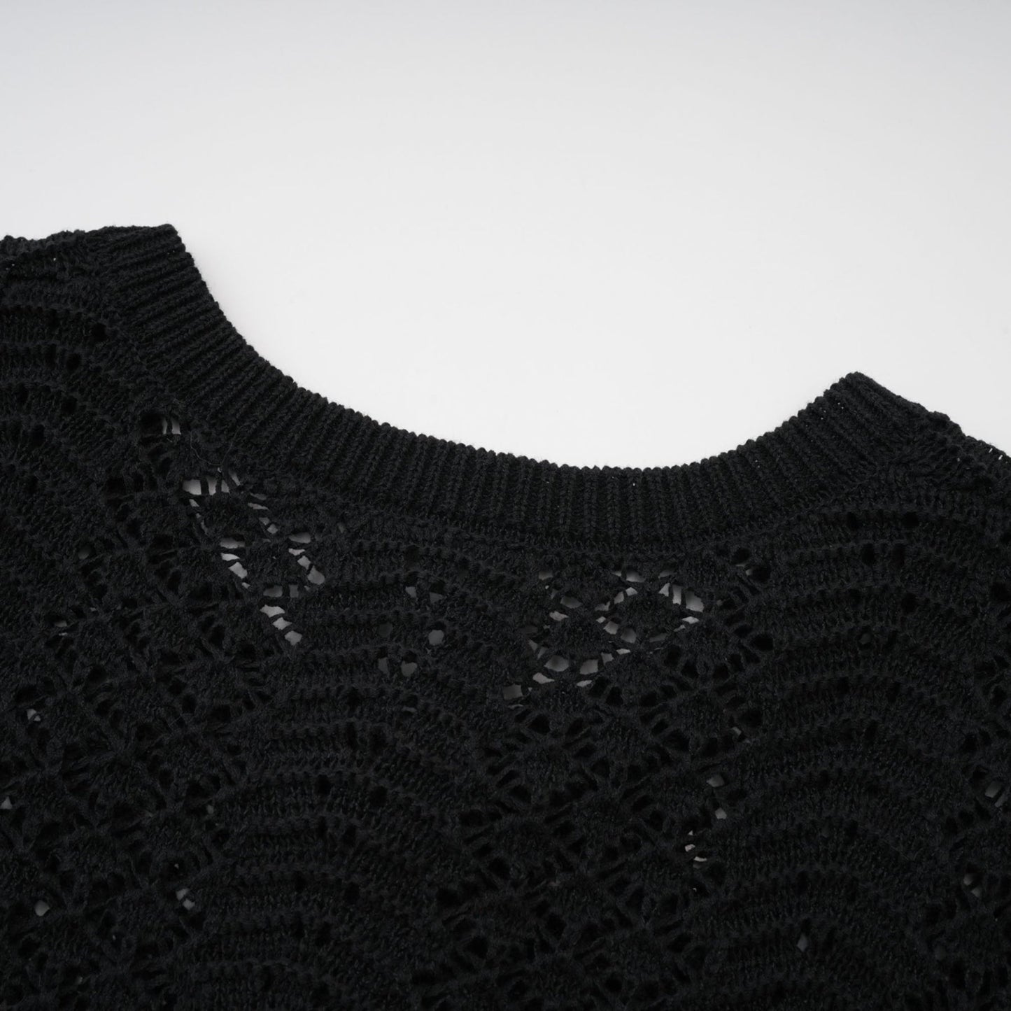Woman wearing black sequined crochet knit cardigan and matching skirt set