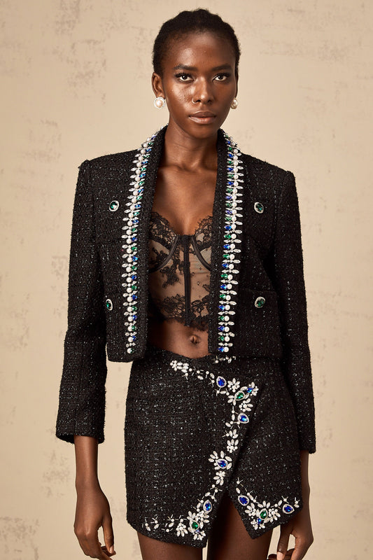 Woman wearing black tweed jacket and matching skirt set with crystal embellishments elegant formal outfit