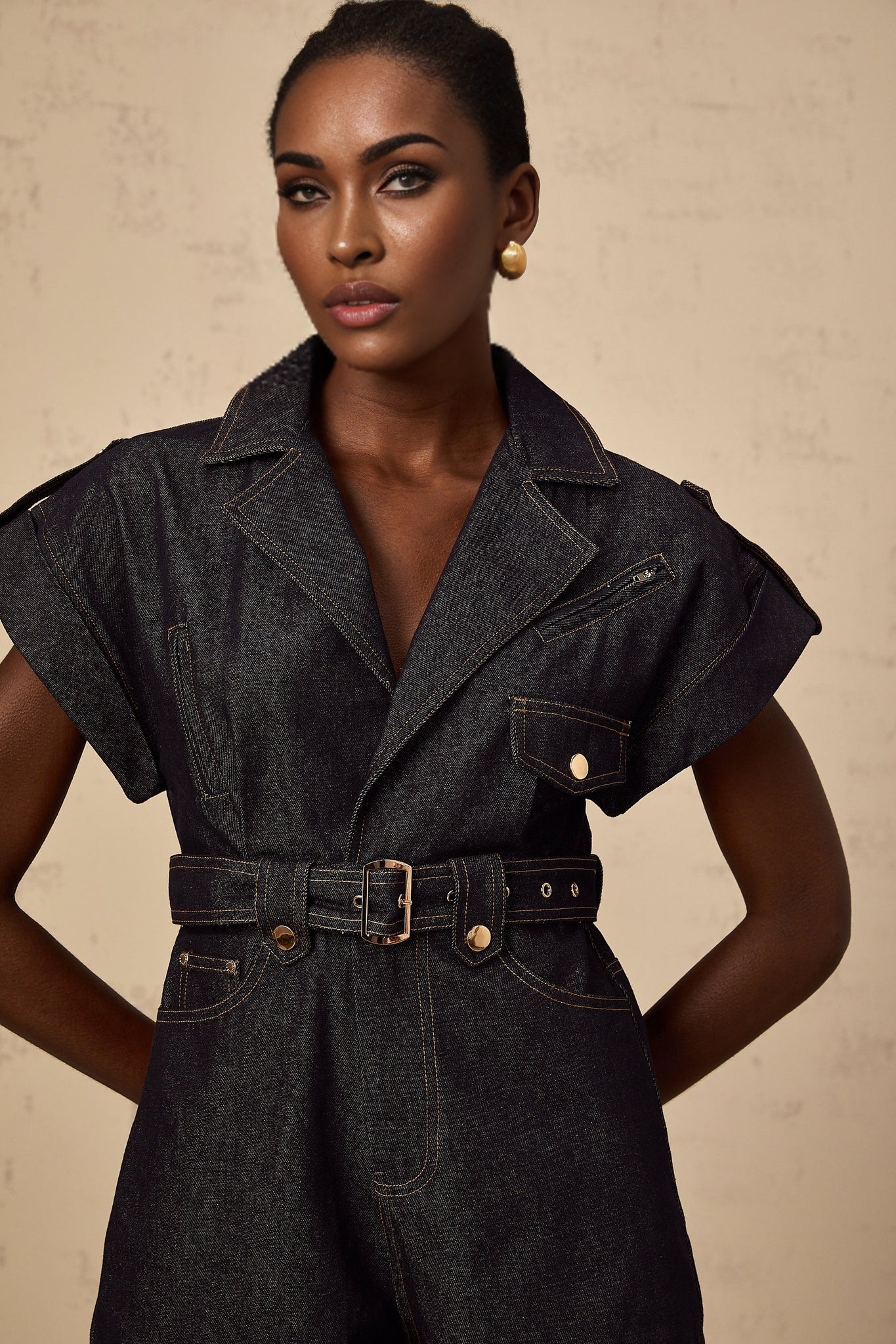 Woman wearing blue denim belted playsuit by Chloe short sleeve romper with cinched waist and wide leg design