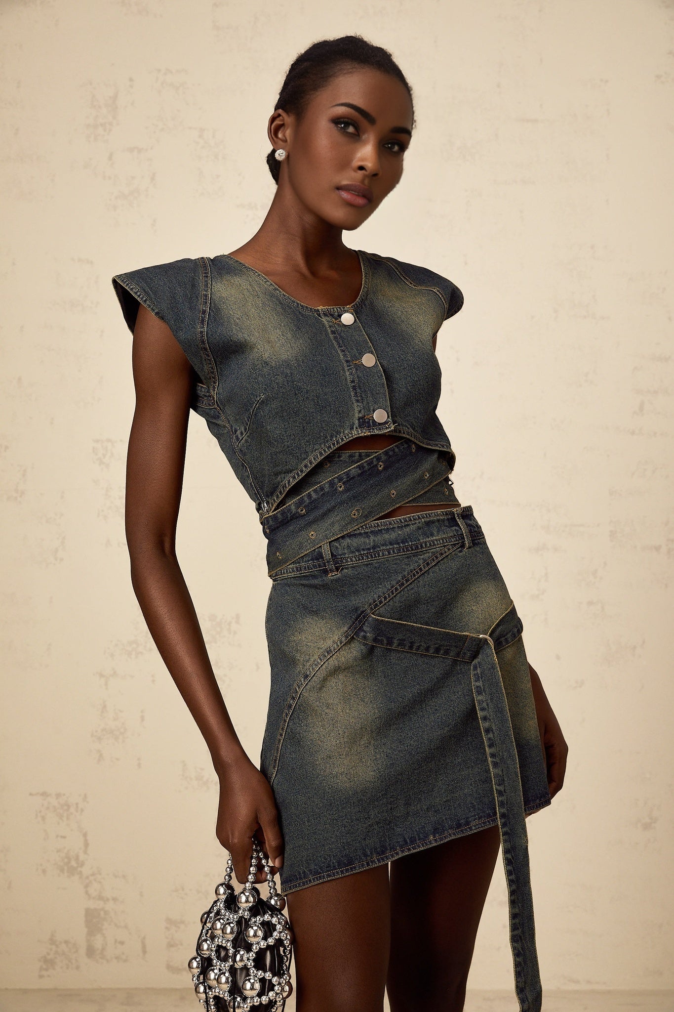 Woman wearing blue denim crossover top with matching denim skirt in fanny pack style set