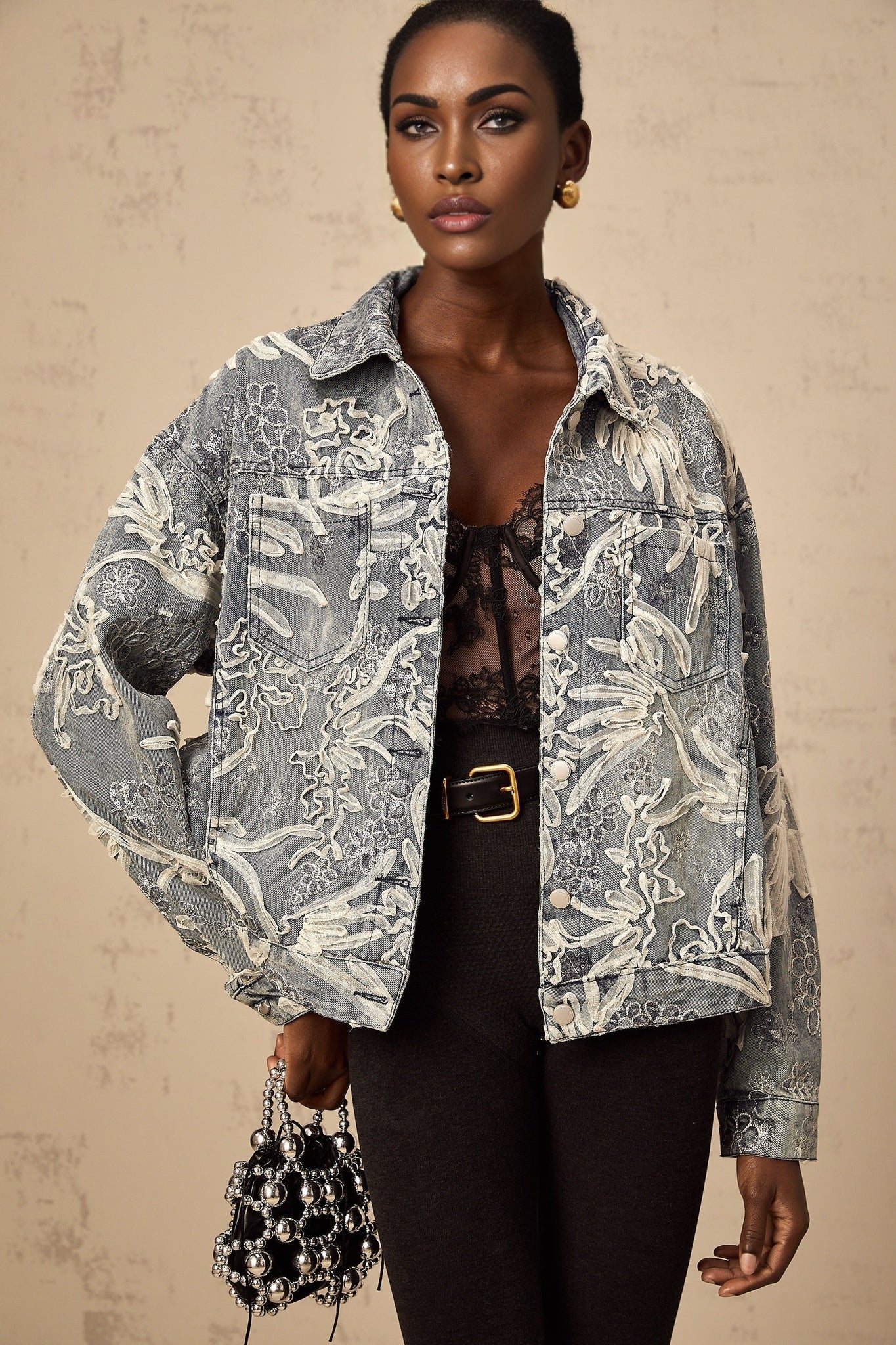Woman wearing blue denim jacket with sequined flower embroidery design