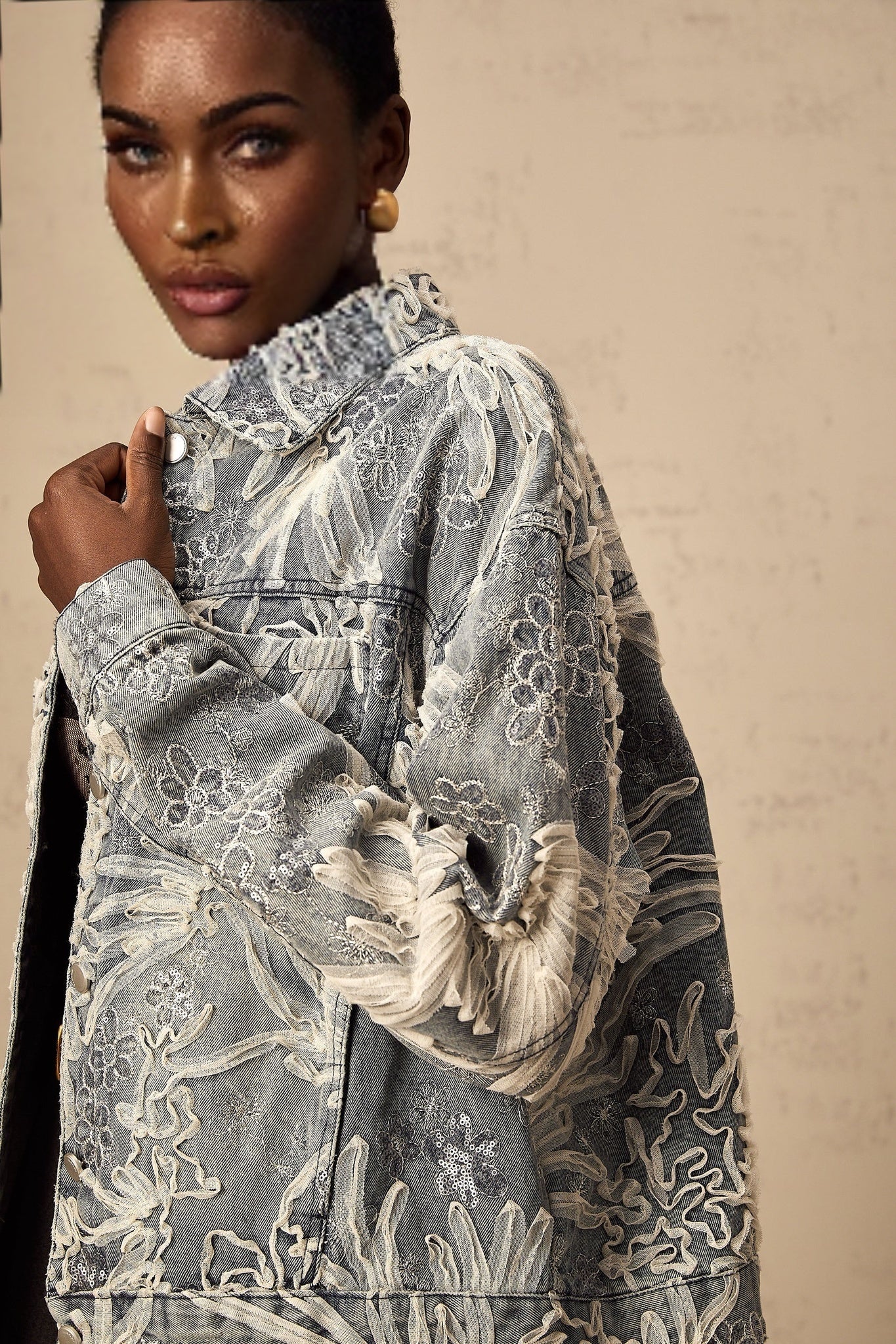 Woman wearing blue denim jacket with sequined flower embroidery design