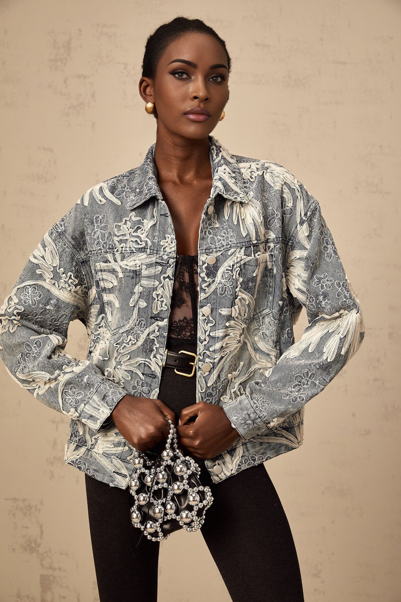 Woman wearing blue denim jacket with sequined flower embroidery design
