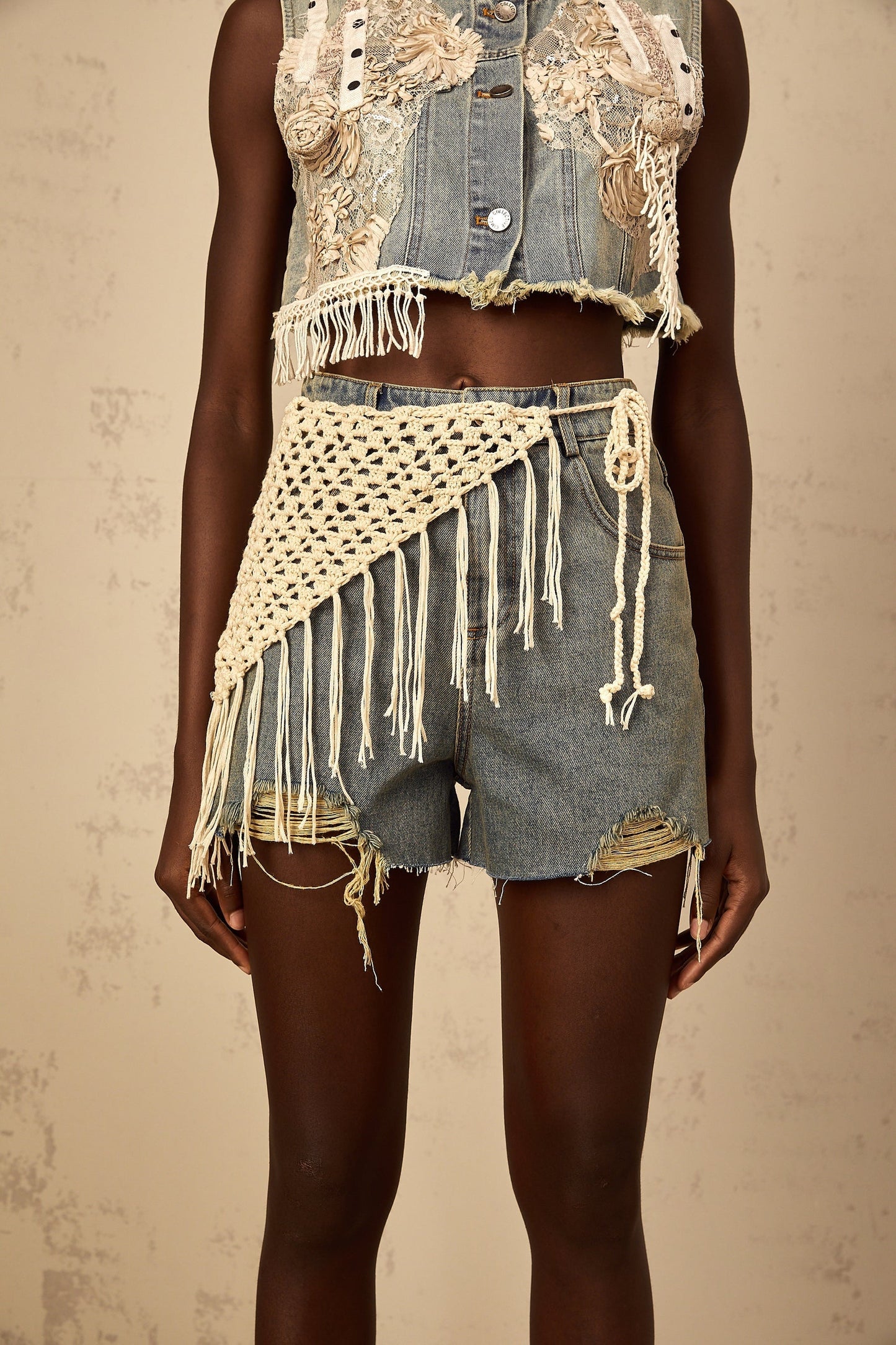 Woman wearing blue denim shorts with bohemian style embroidery and frayed hem