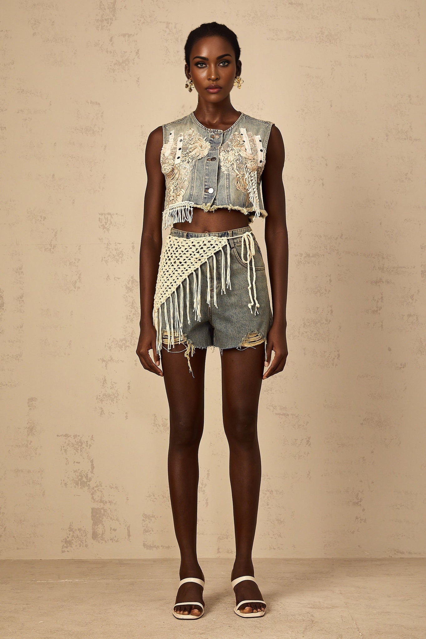 Woman wearing blue denim shorts with bohemian style embroidery and frayed hem
