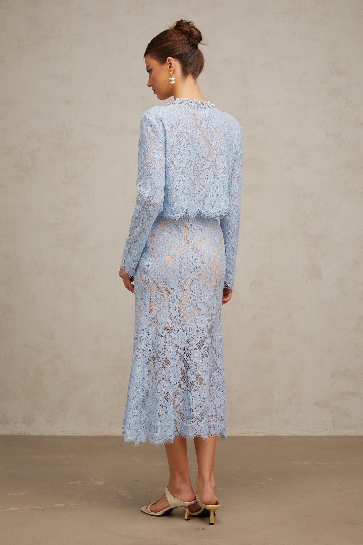 Woman wearing blue floral lace matching set consisting of a top and skirt Ariane design