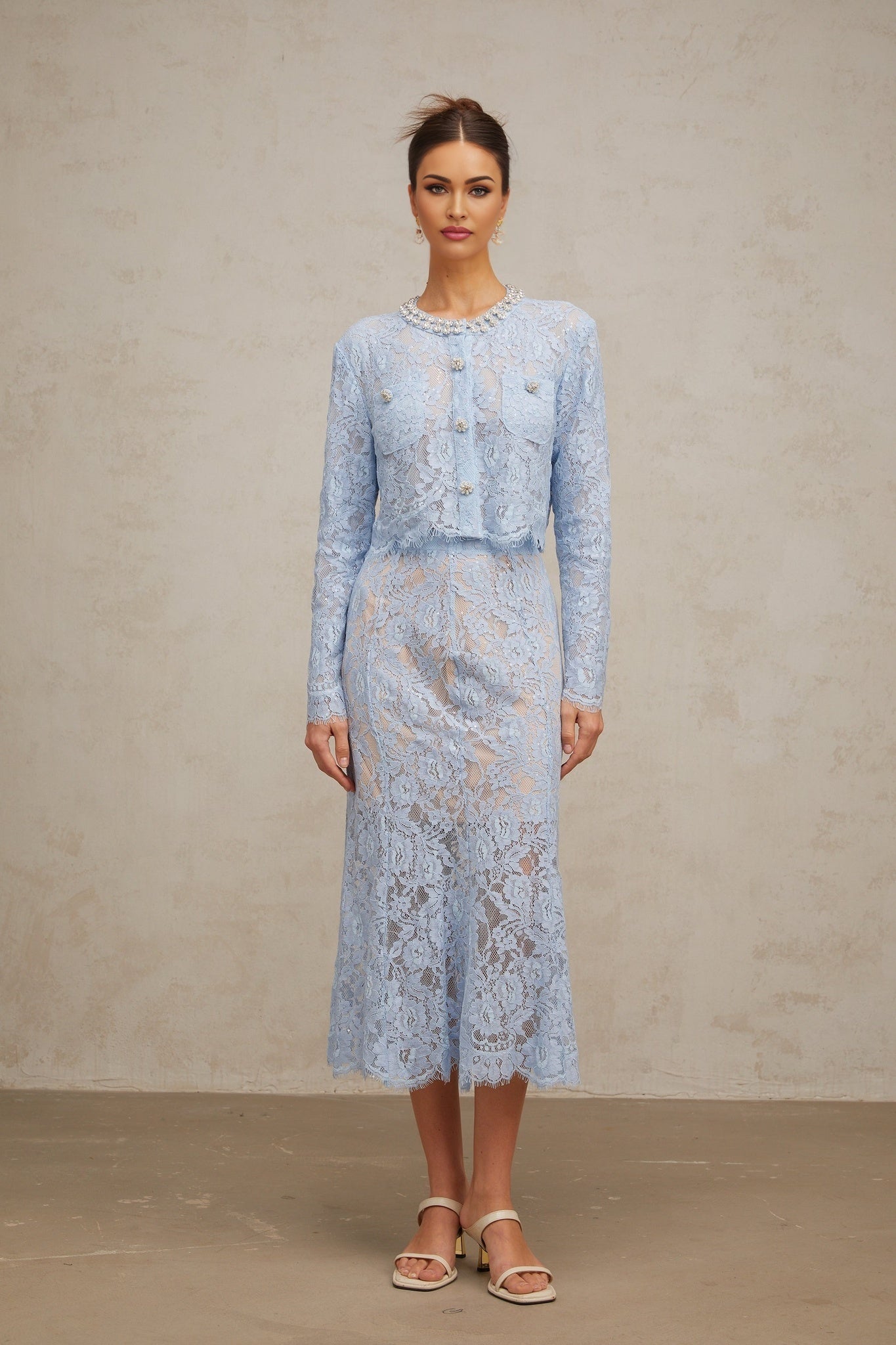 Woman wearing blue floral lace matching top and skirt set with delicate pattern and feminine design