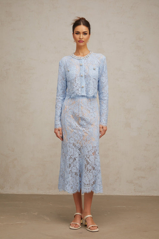 Woman wearing blue floral lace matching top and skirt set with delicate pattern and feminine design