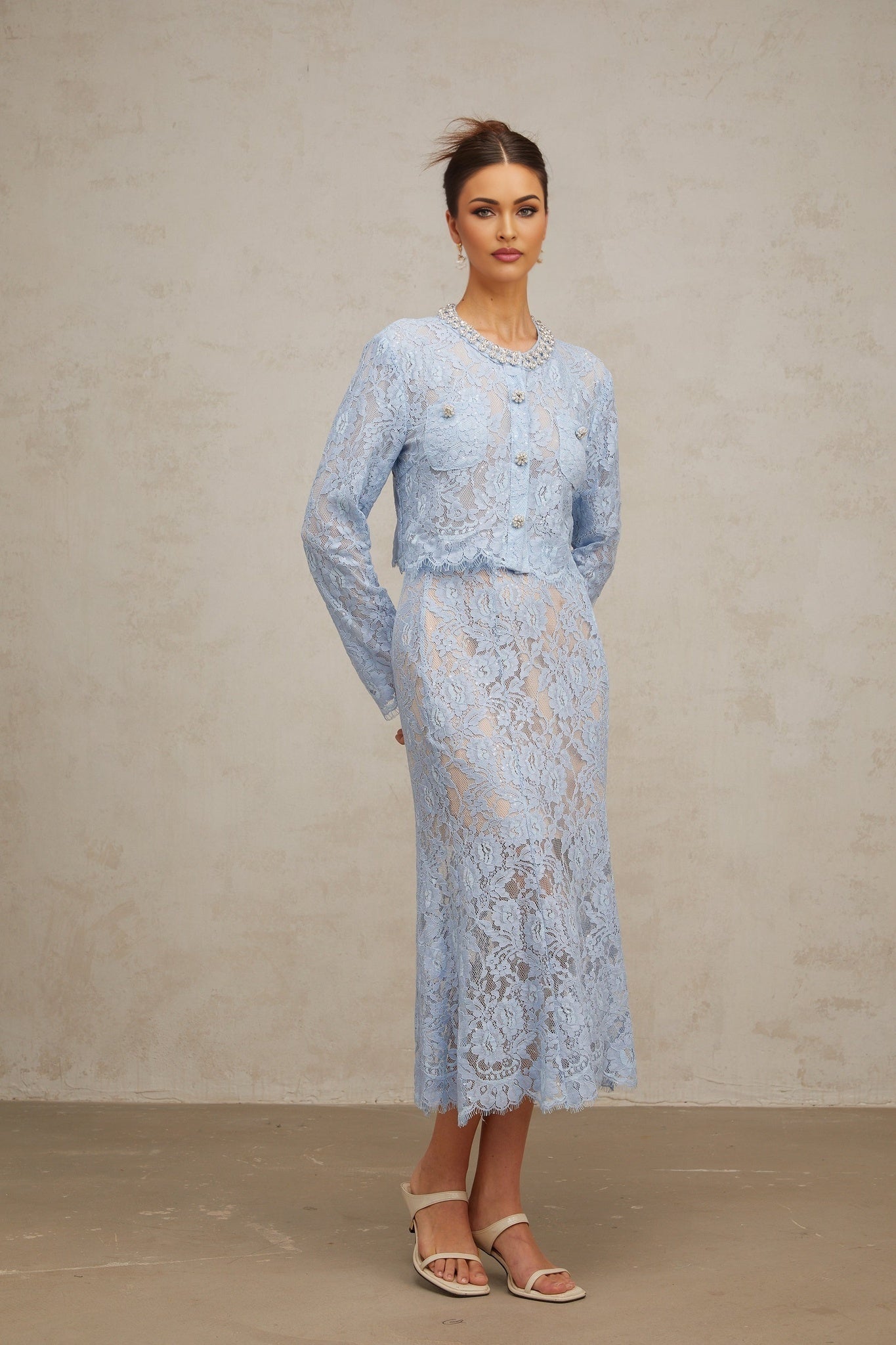 Woman wearing blue floral lace top and matching skirt set named Ariane