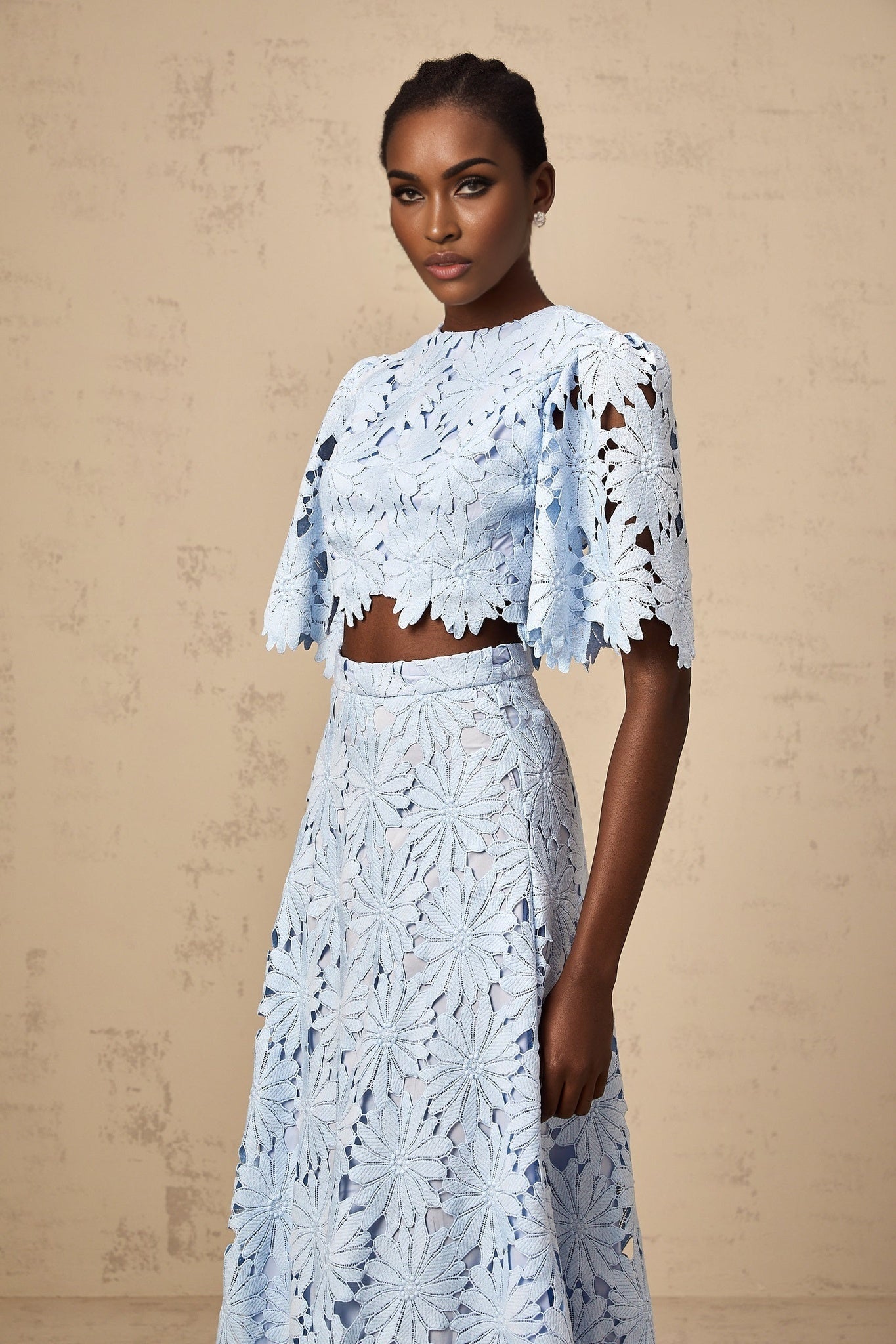 Woman wearing blue lace top and matching skirt set called Audrey