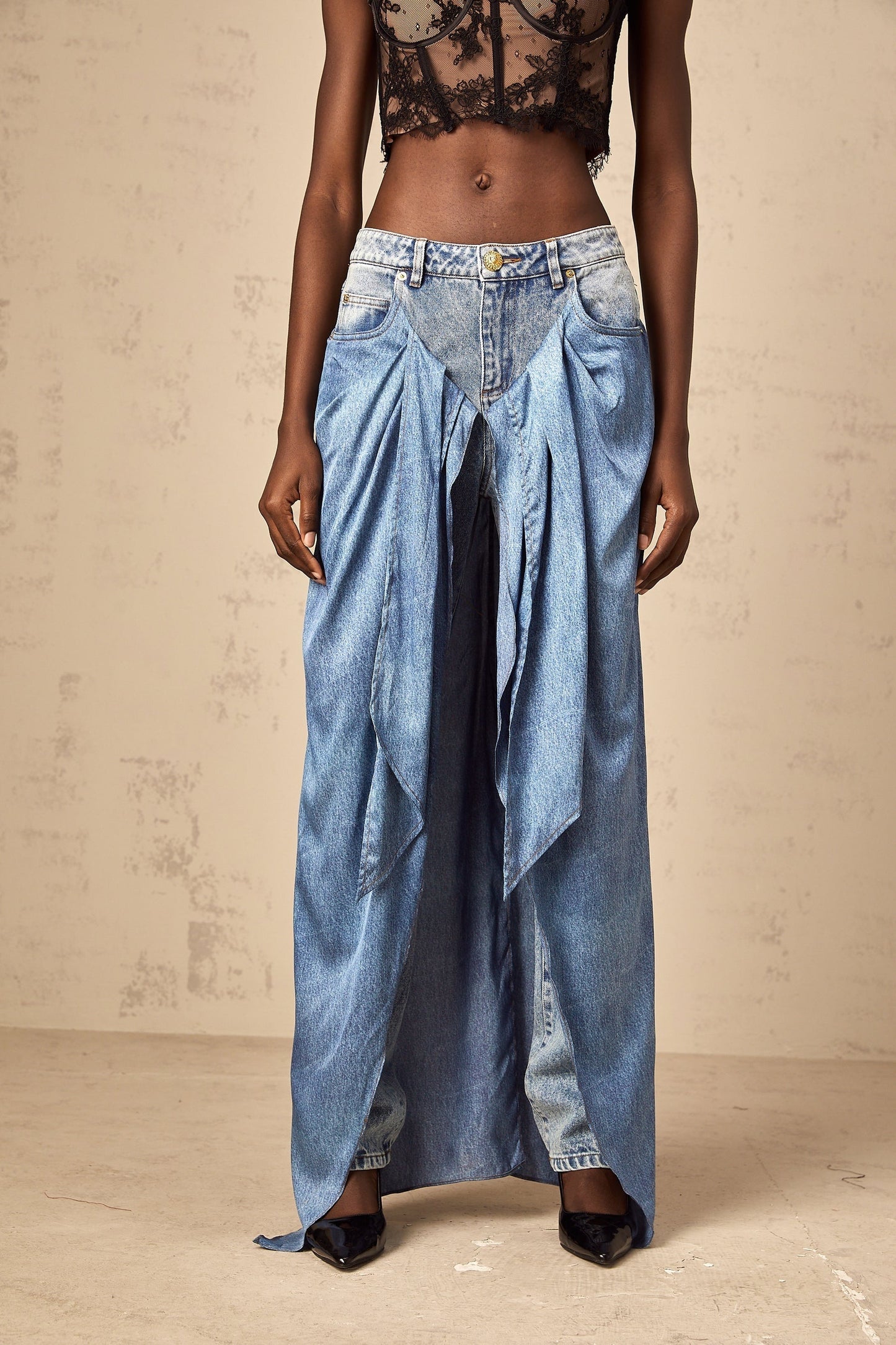Woman wearing blue layered denim jeans with a distressed look and multiple tiers of fabric