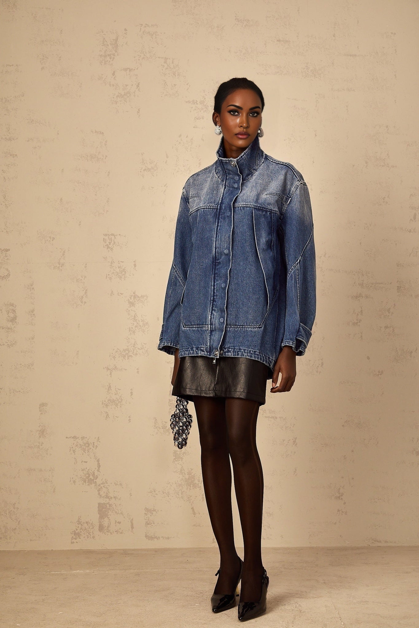 Woman wearing blue patchwork denim jacket with loose fit and light wash design