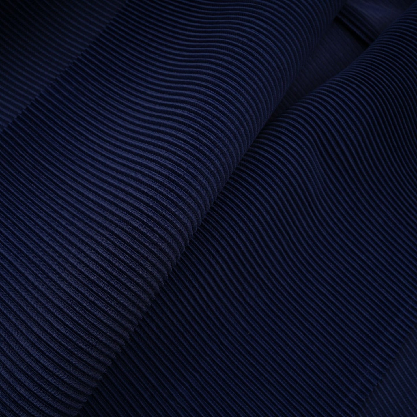 Woman wearing blue patterned cape and matching skirt set with creased fabric design