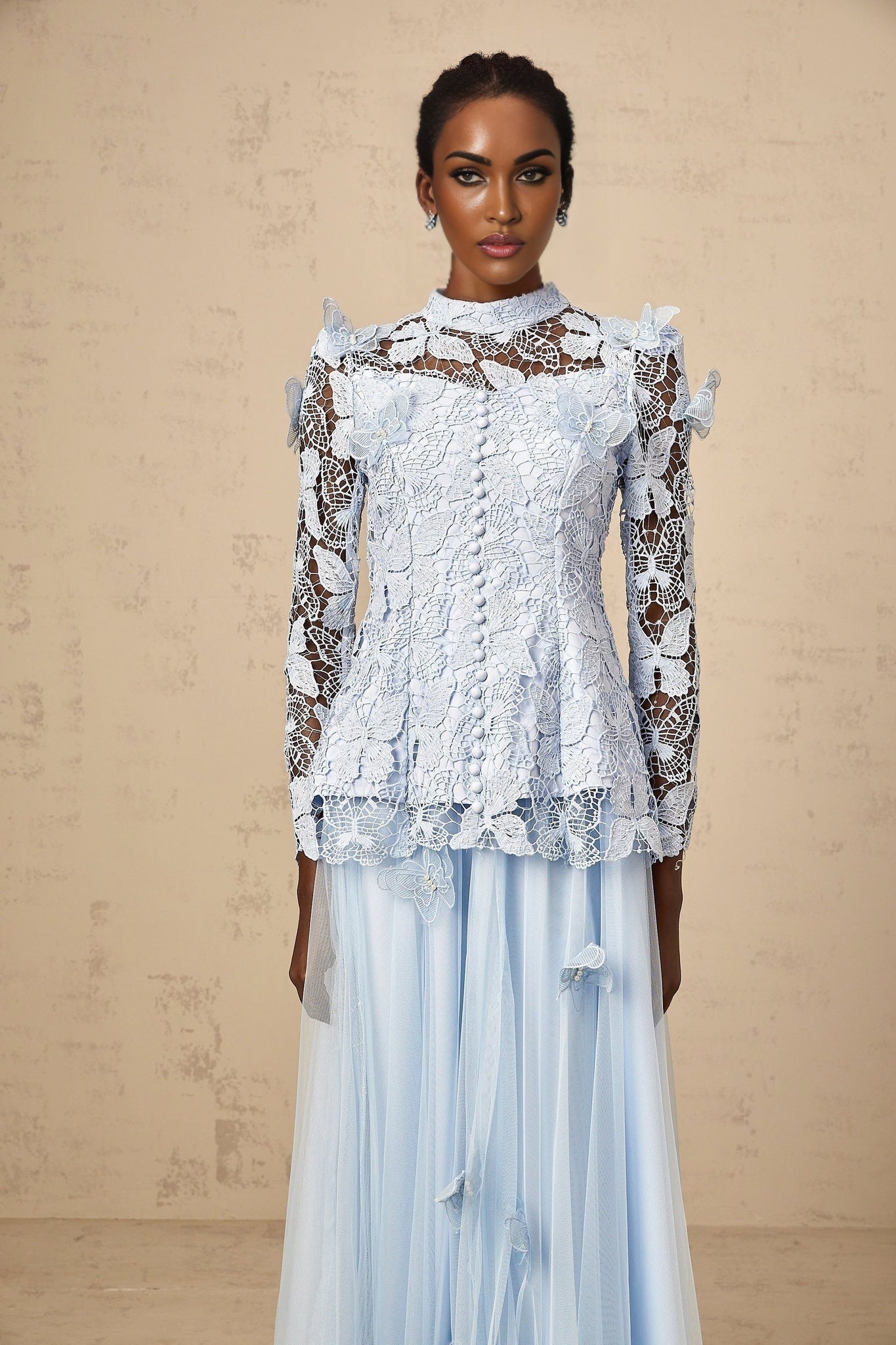 Woman wearing blue sequined lace top and matching skirt set with shimmering details