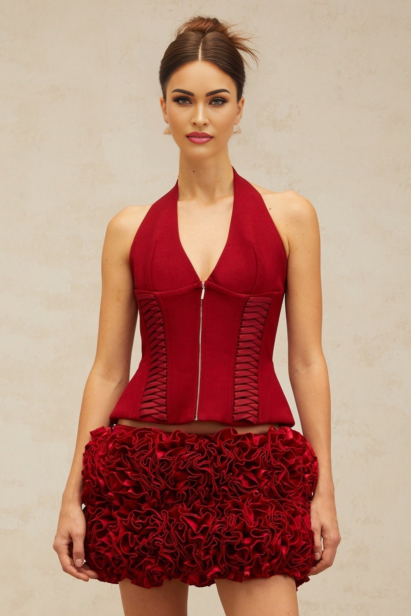 Woman wearing bright red halterneck top with laceup front detail
