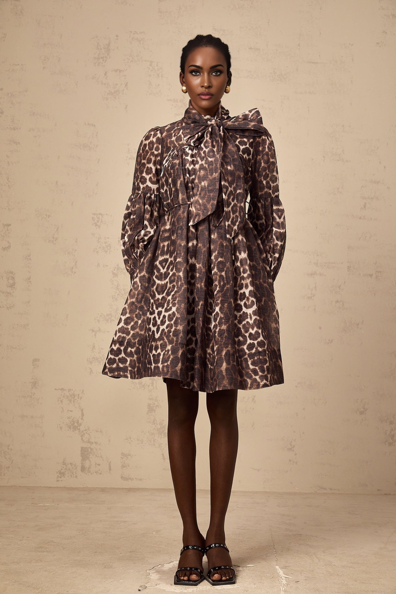Woman wearing brown leopard print mini dress with bowknot detail