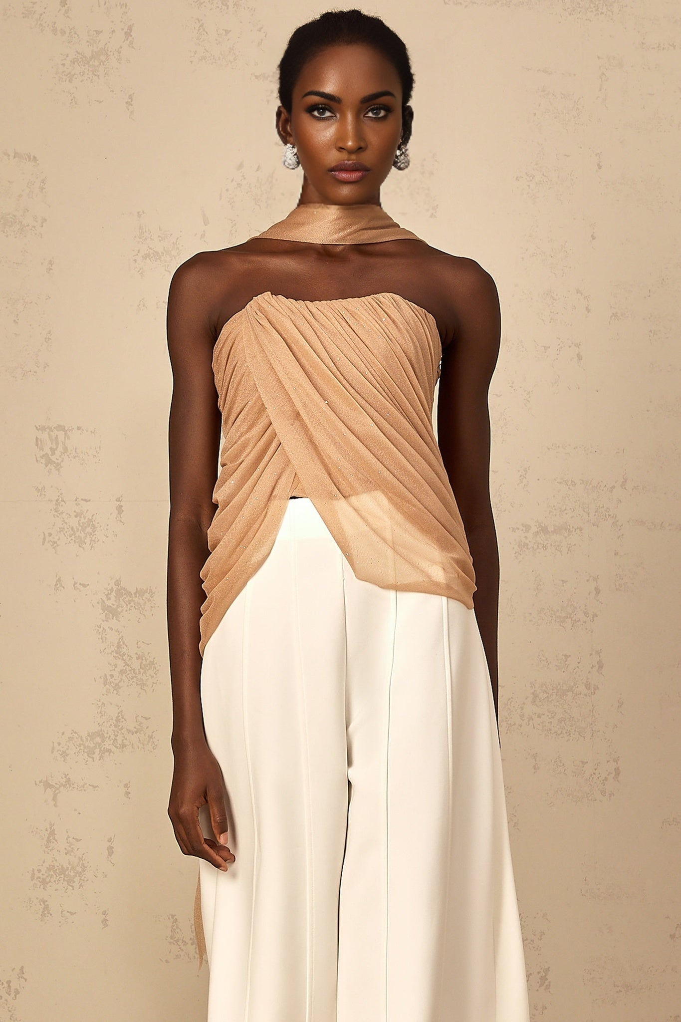 Woman wearing brown sleeveless top with sequin embellishments and ruched tulle detailing