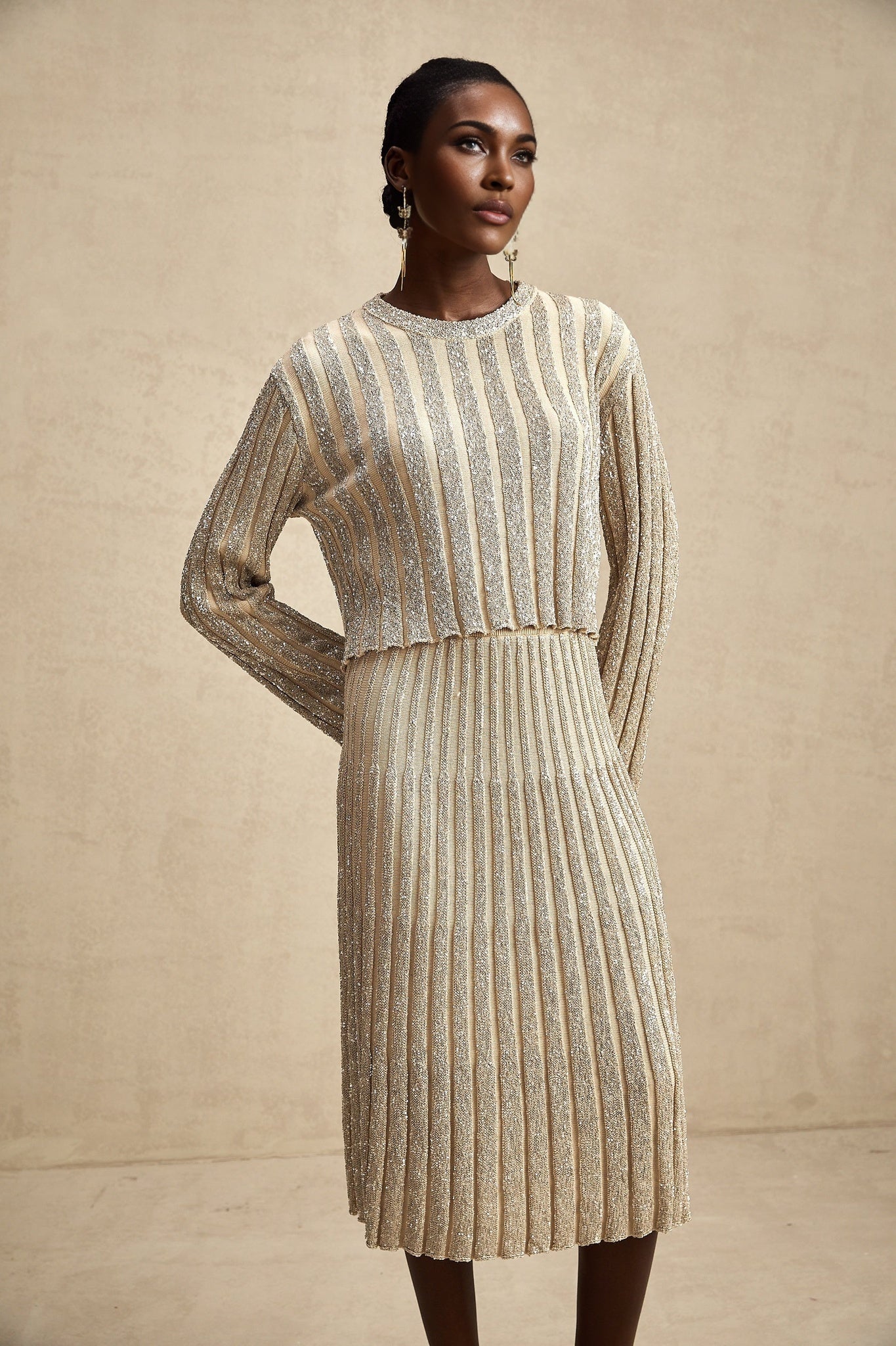 Woman wearing champagne colored knit top and skirt set with vertical stripes elegant matching outfit for formal occasions