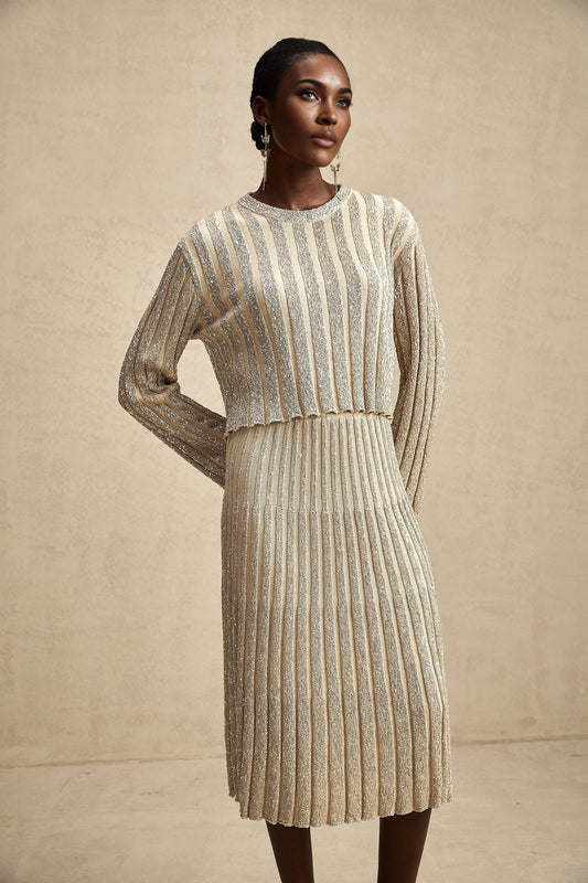 Woman wearing champagne colored knit top and skirt set with vertical stripes elegant matching outfit for formal occasions