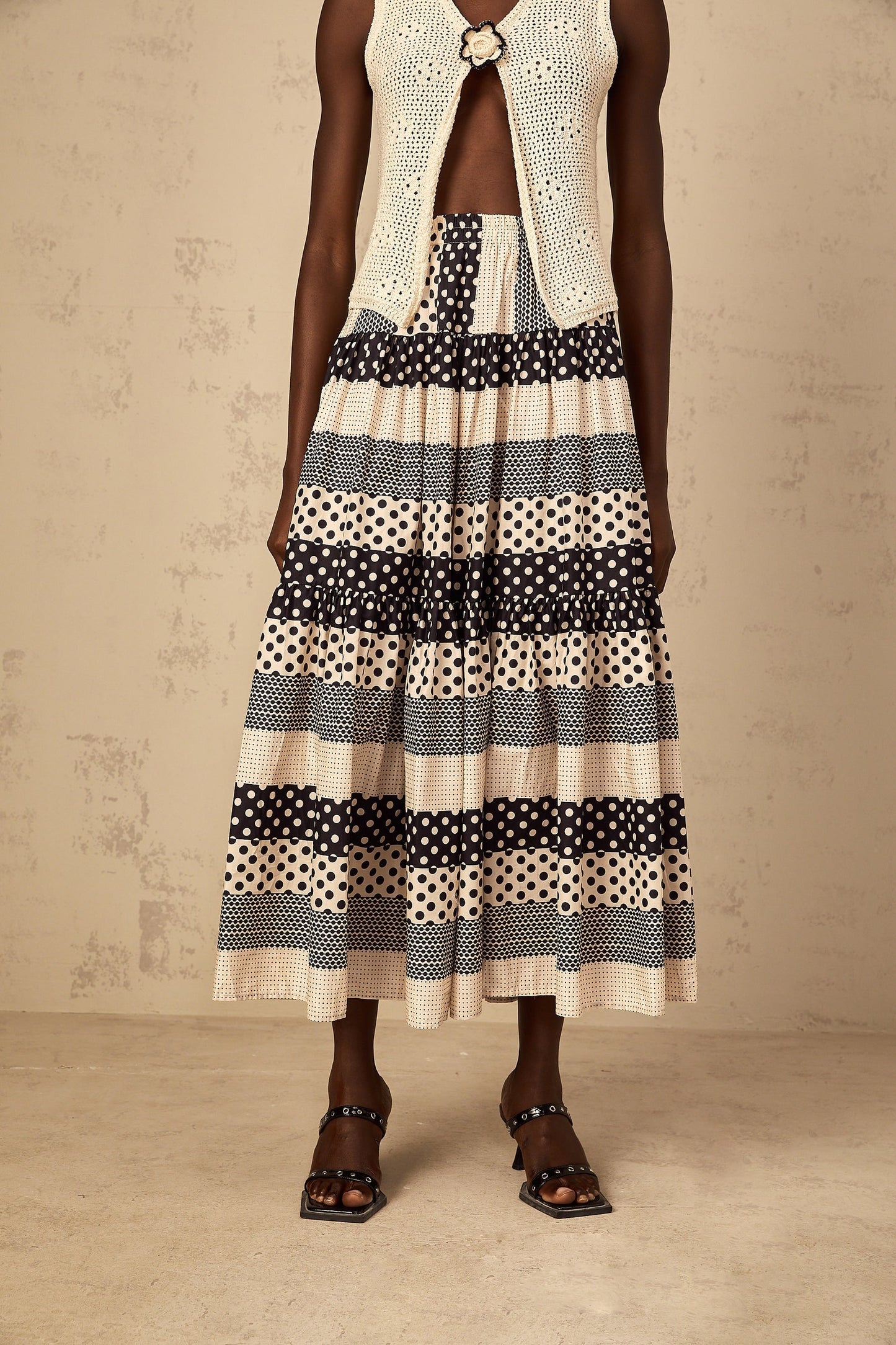 Woman wearing color block skirt with shirred waist polka dot pattern and contrasting solid sections