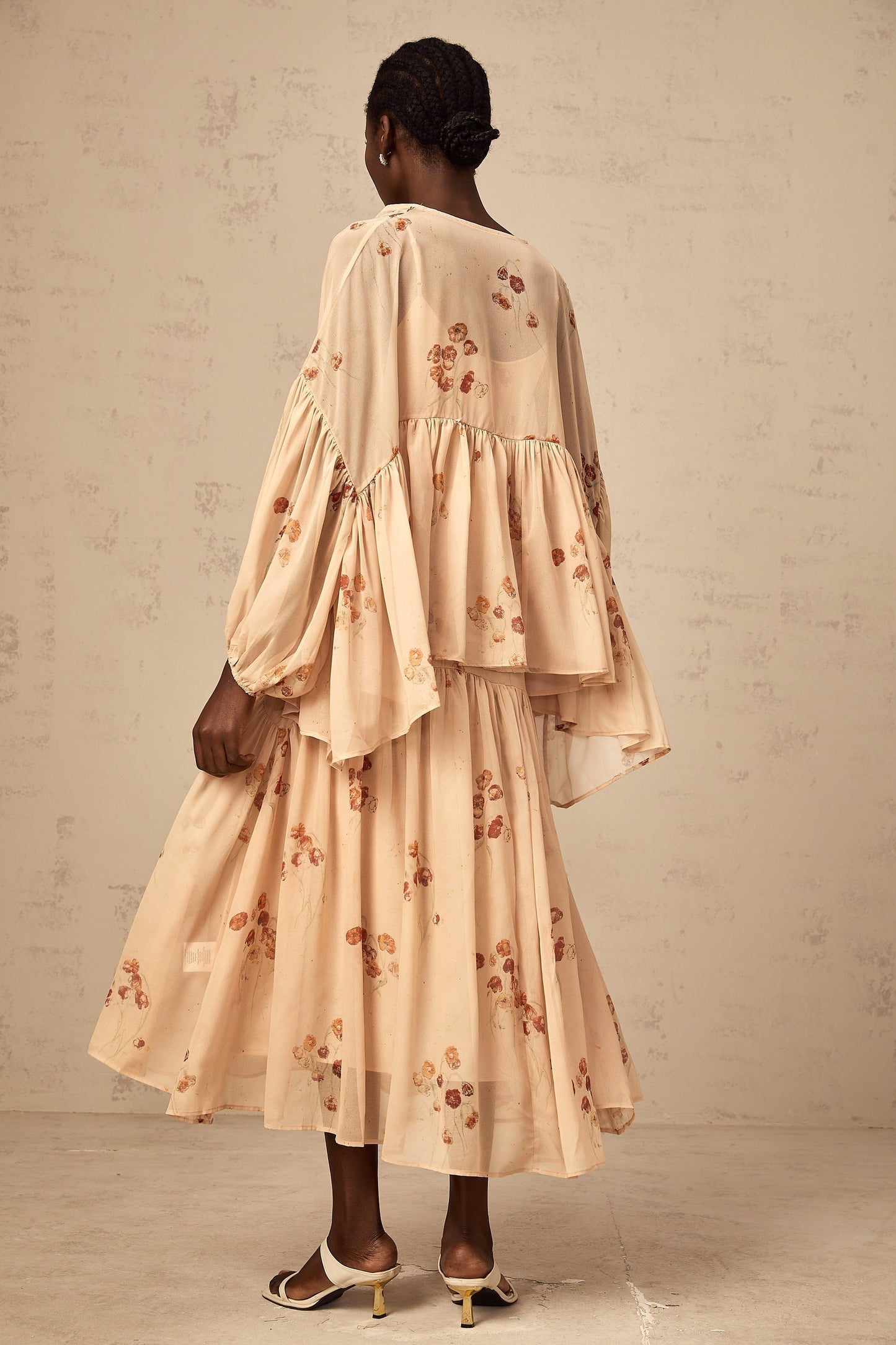 Woman wearing coralpink floral print matching set with pleated blouse and dress Maia collection