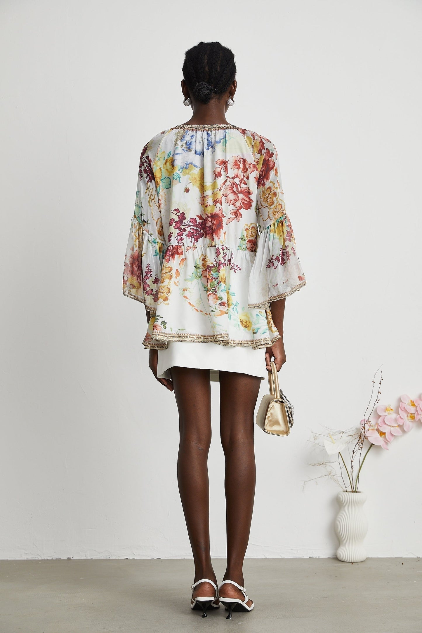 Woman wearing floral print blouse with v neck named Yvonne