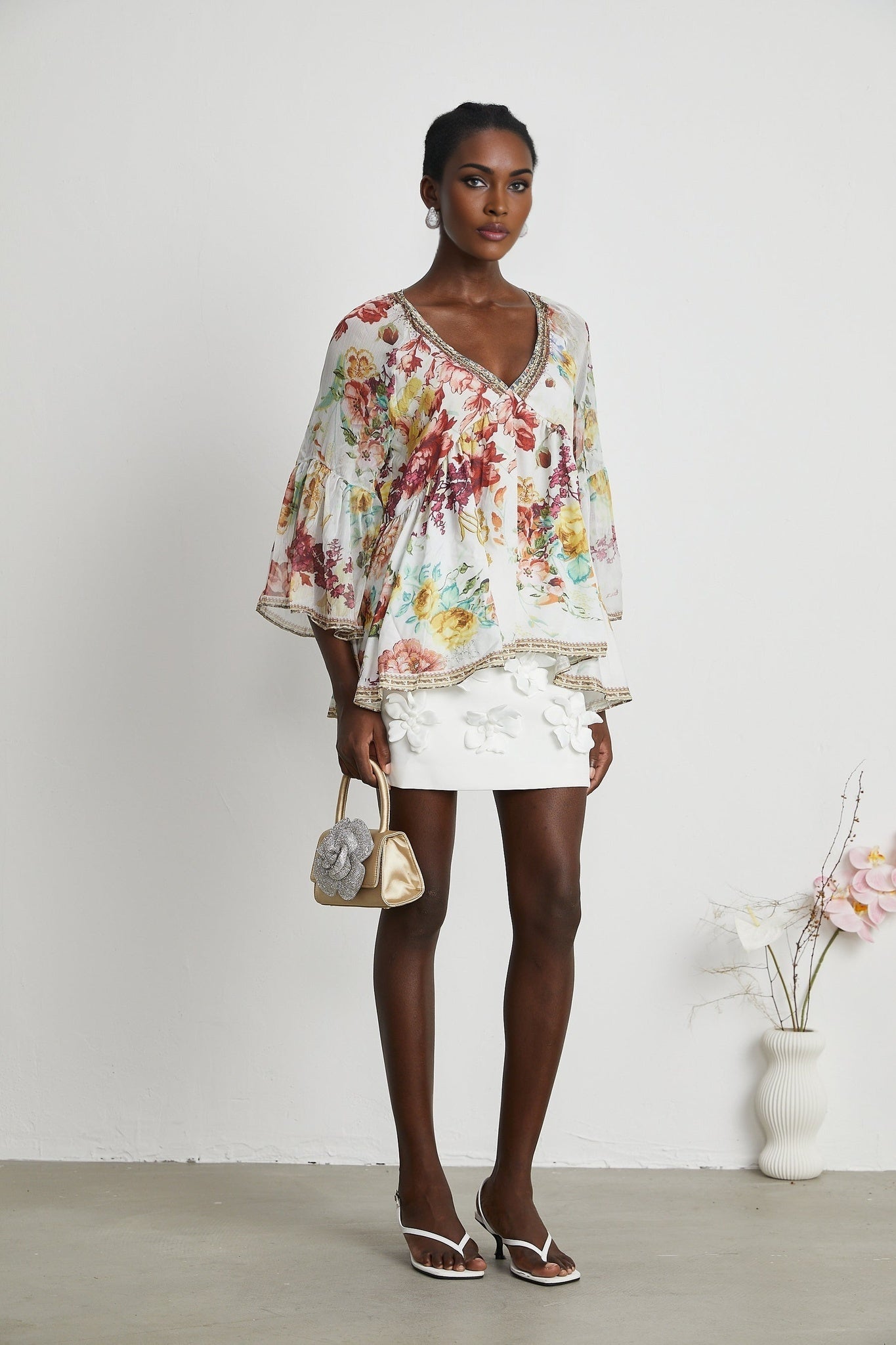 Woman wearing floral print blouse with V neckline named Yvonne