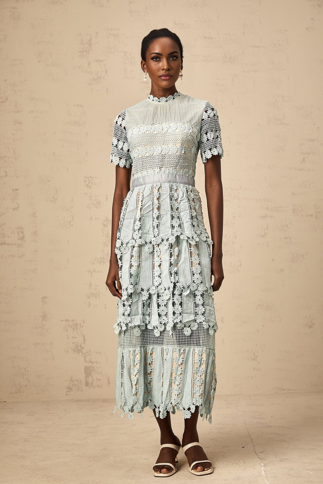 Woman wearing green midi dress with floral embroidery pattern