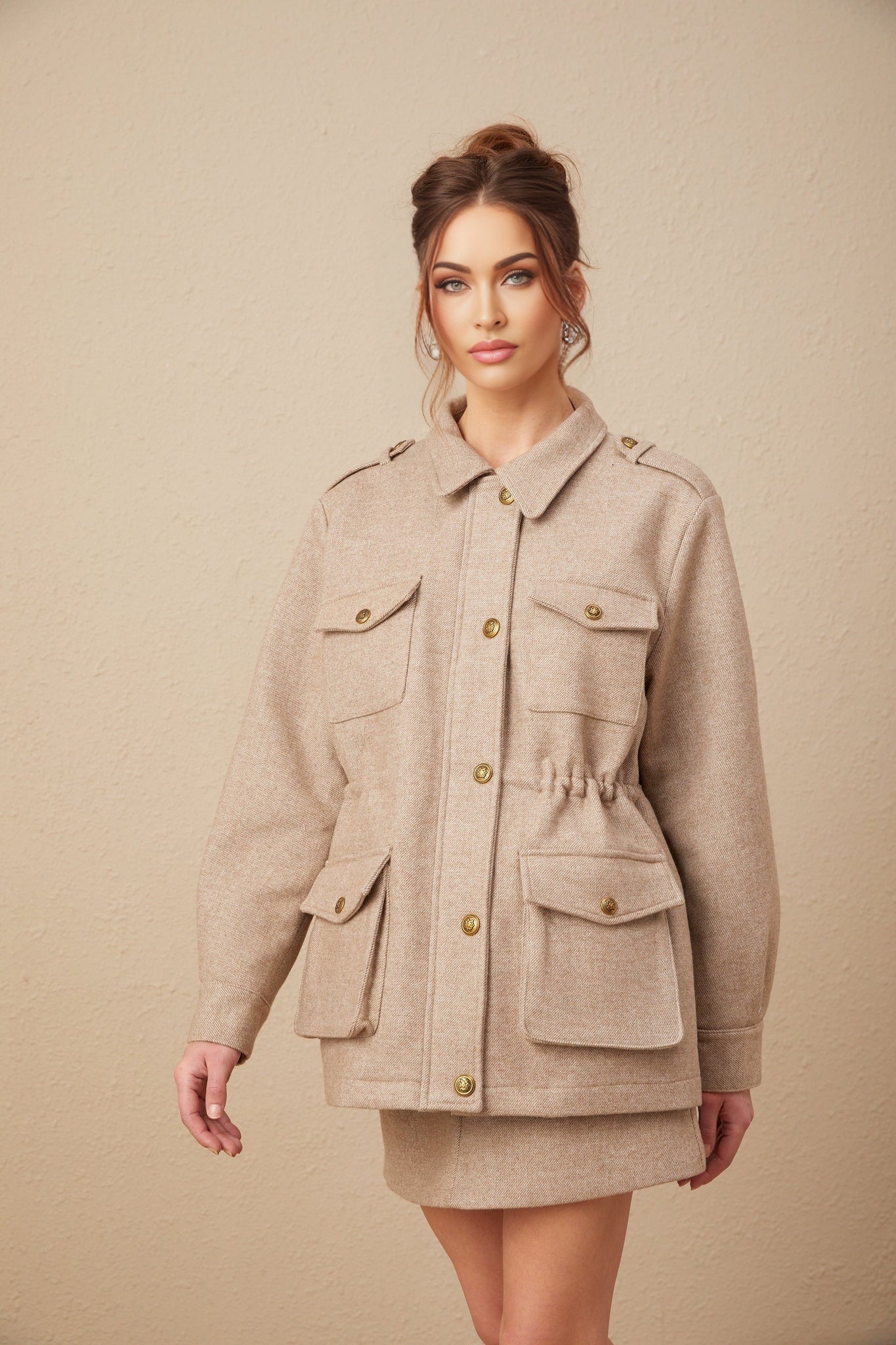 Woman wearing khaki wool twill jacket and matching culottes standing in neutral pose against plain background