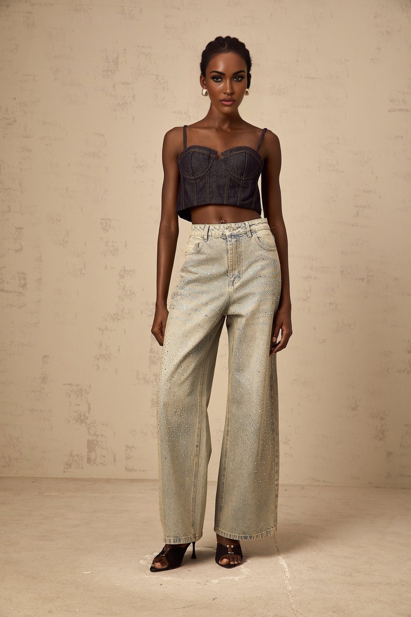 Woman wearing light blue denim jeans adorned with rhinestone embellishments