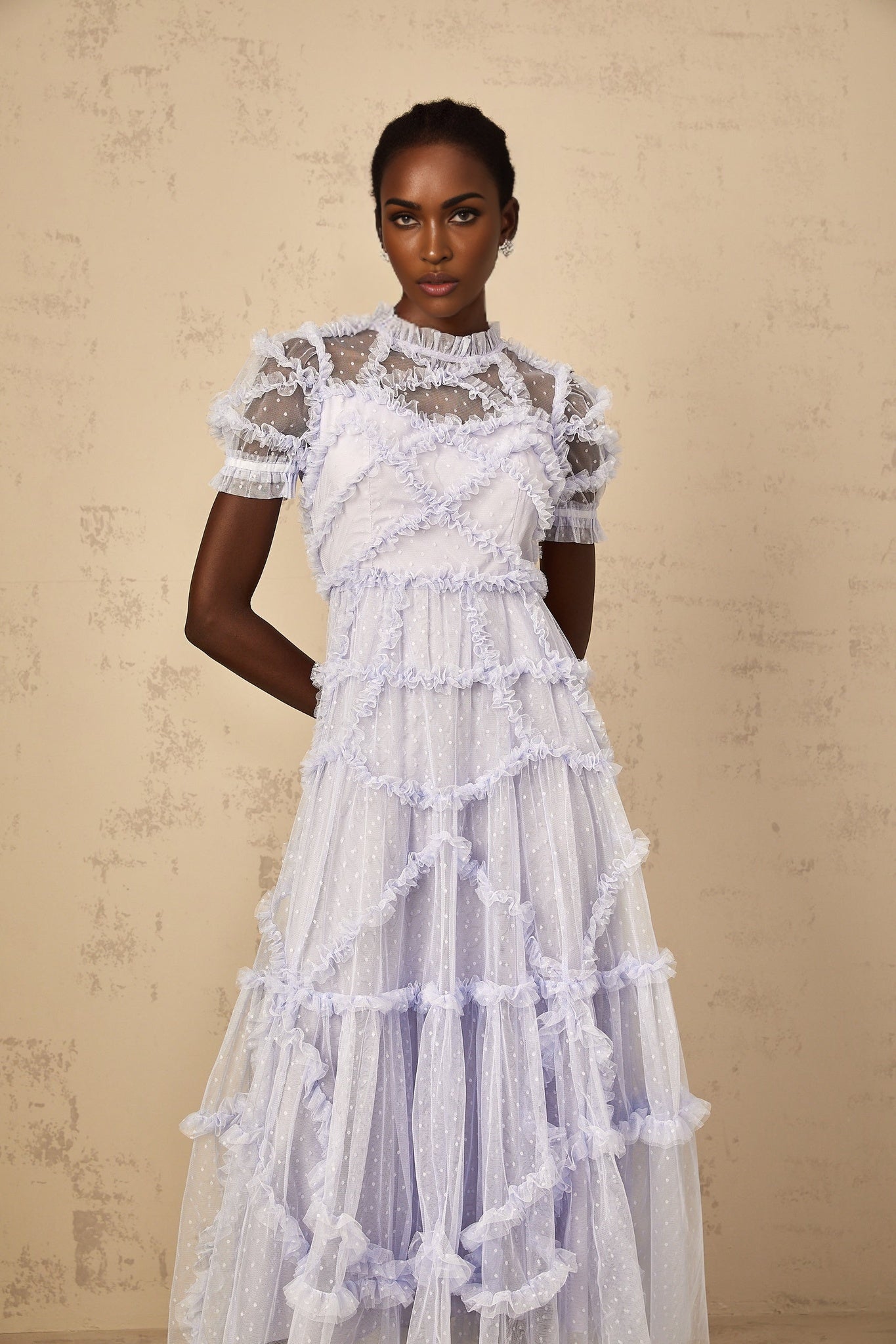 Woman wearing long blue maxi dress with white polka dots and ruffled tulle details