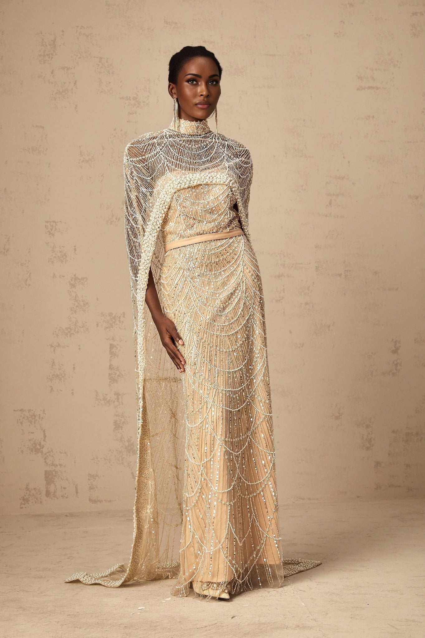 Woman wearing long champagne gown with matching beaded cape elegant formal dress ensemble