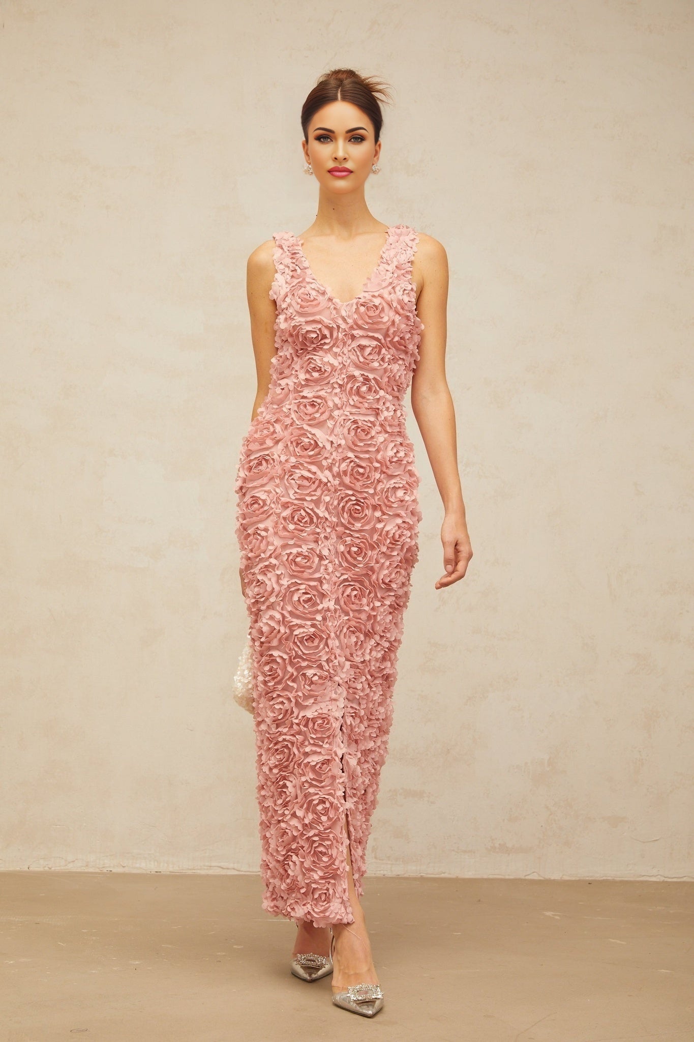 Woman wearing long pink floral maxi dress with Vneck and faux flower pattern