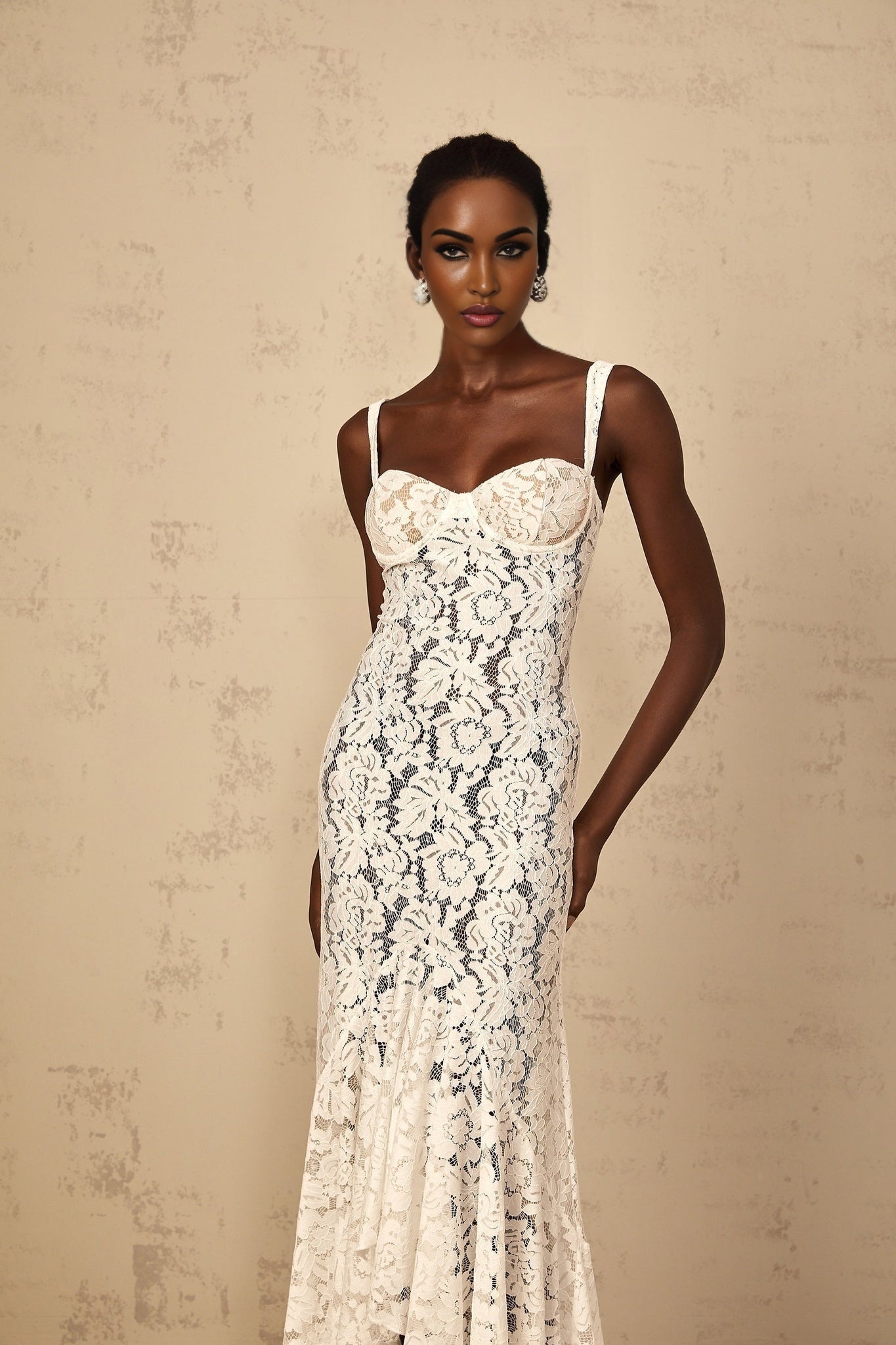 Woman wearing long white lace dress with floral pattern and bustier top