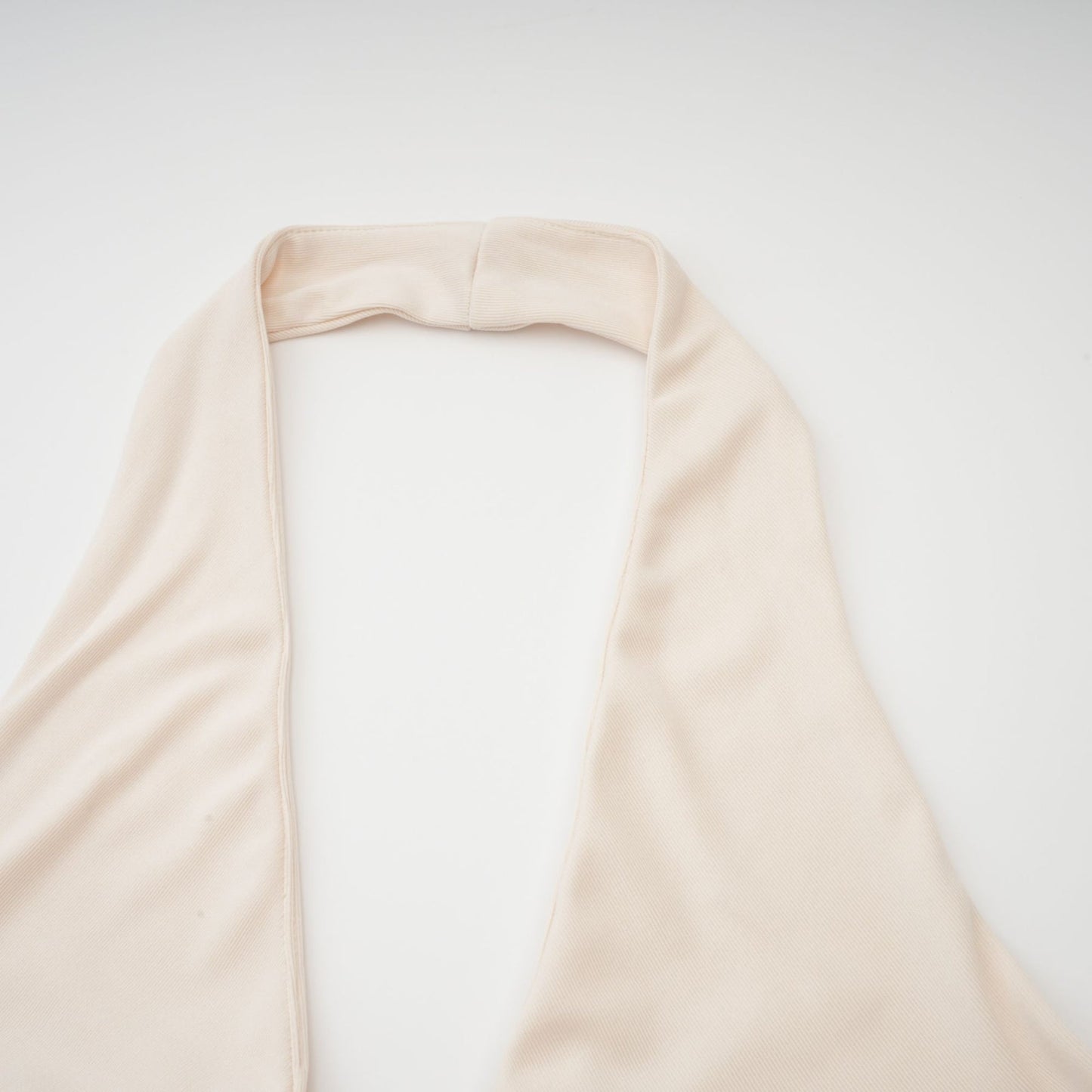 Woman wearing long white maxi dress with deep V neckline and draped fabric
