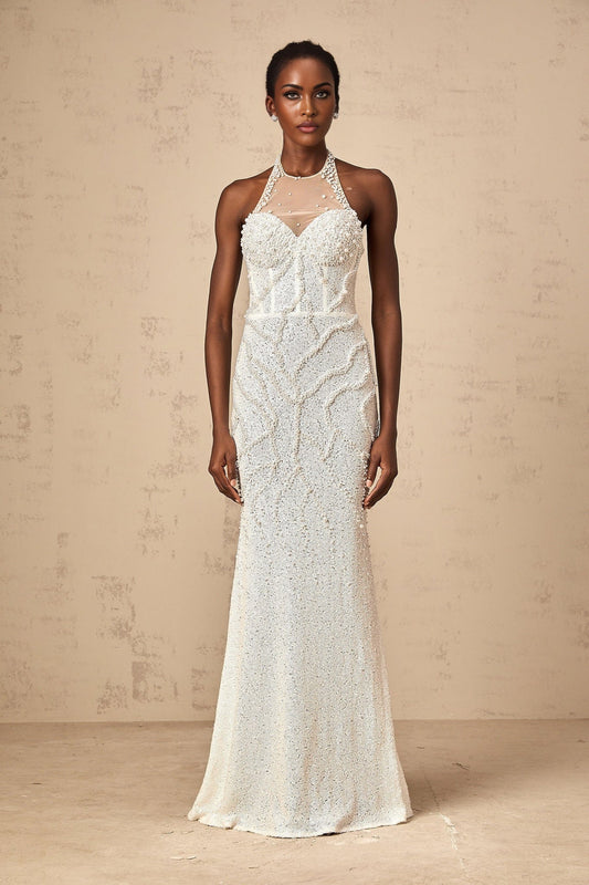 Woman wearing long white maxi dress with faux pearl embellishments