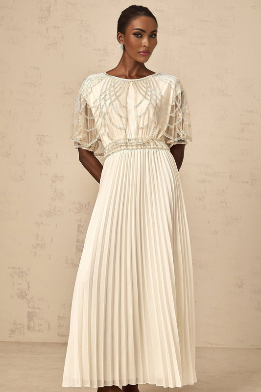 Woman wearing long white pleated maxi dress with crystal embellishments
