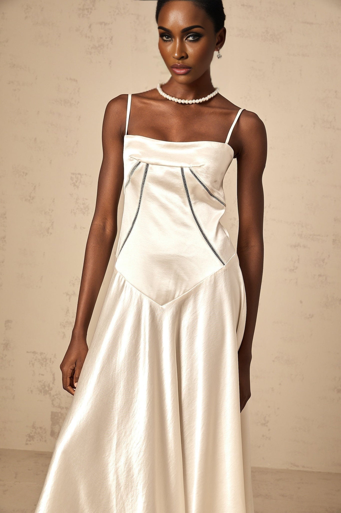 Woman wearing long white satin maxi dress with flared skirt