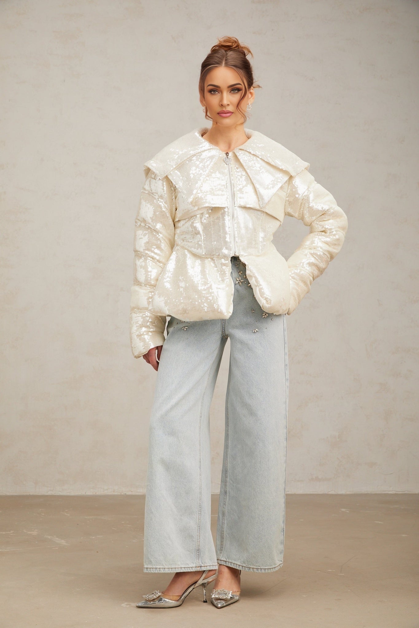 Woman wearing long white winter coat with sequin detailing and down insulation
