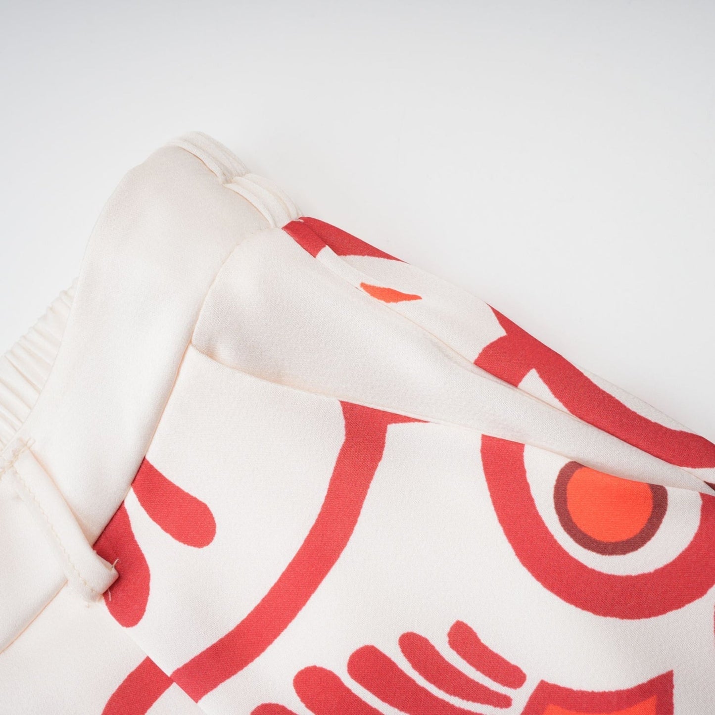 Woman wearing matching floral print shirt and trousers set in vibrant colors Standing casually with hands on hips against plain background