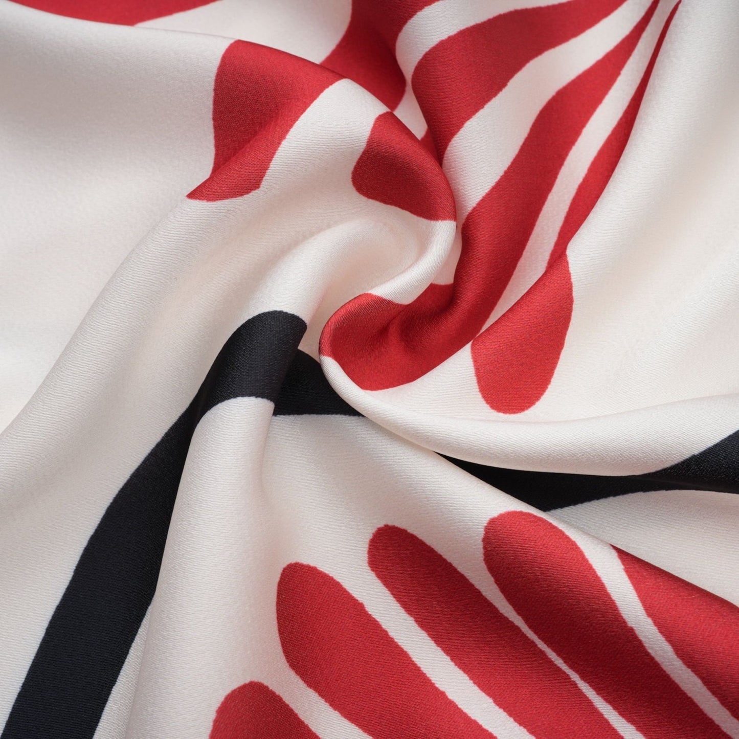 Woman wearing matching floral print shirt and trousers set in vibrant colors with tropical leaf pattern
