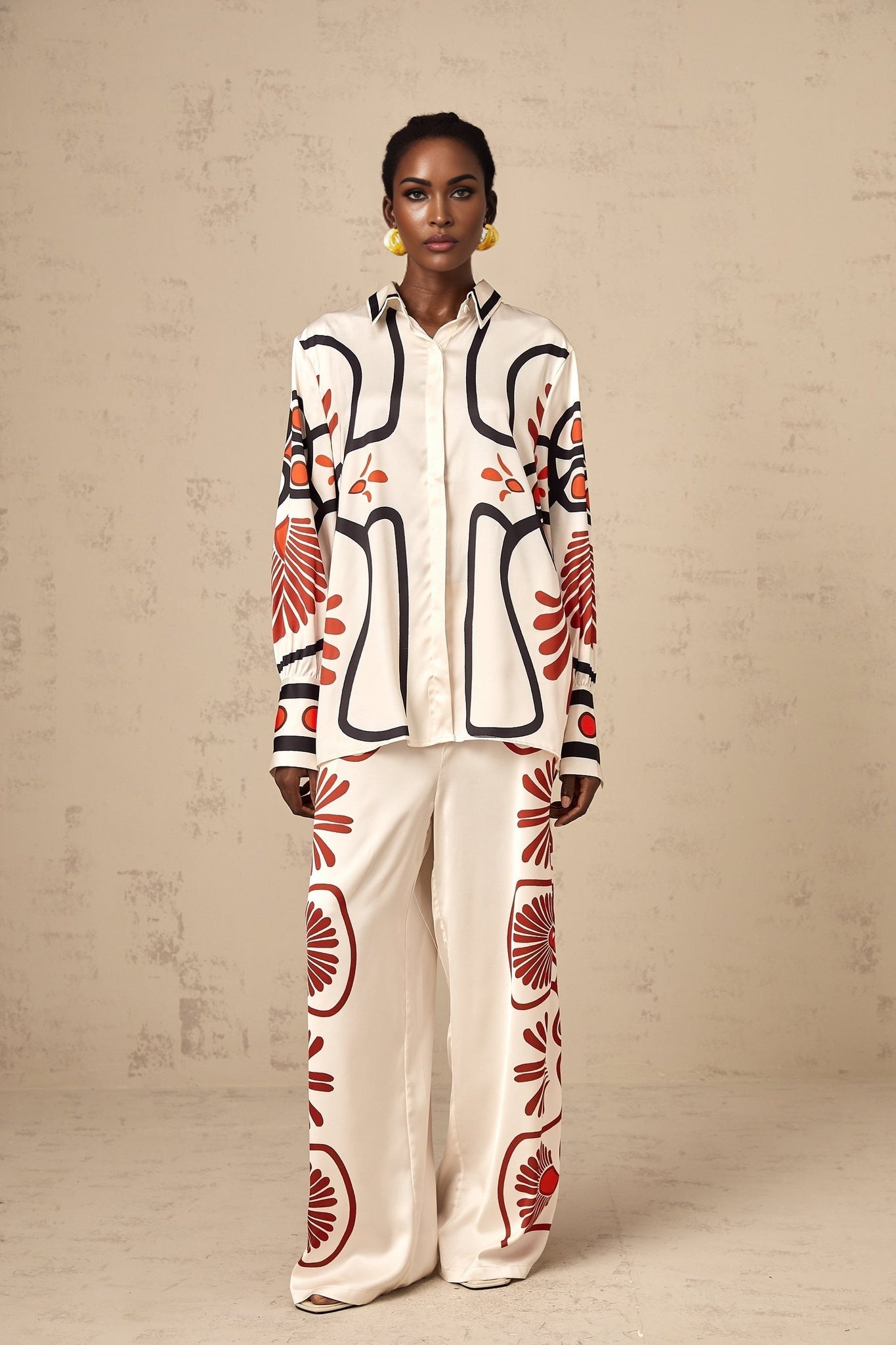 Woman wearing matching floral print shirt and trousers set with vibrant colors and tropical pattern
