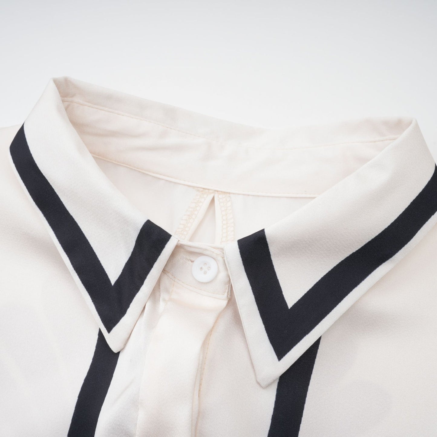 Woman wearing matching graphic print shirt and trousers set in vibrant colors with abstract floral pattern