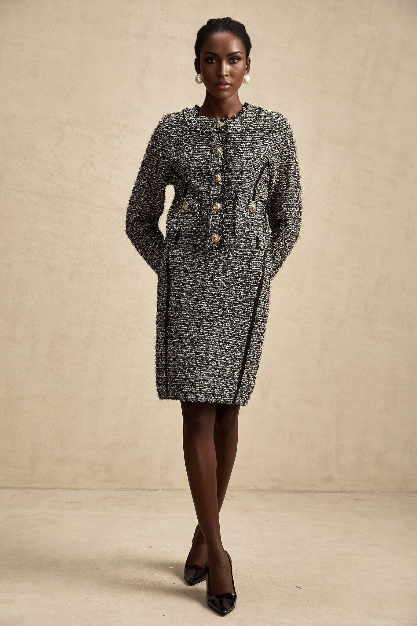 Woman wearing matching jacket and skirt set in contrasting colors with shimmering lurex fabric details