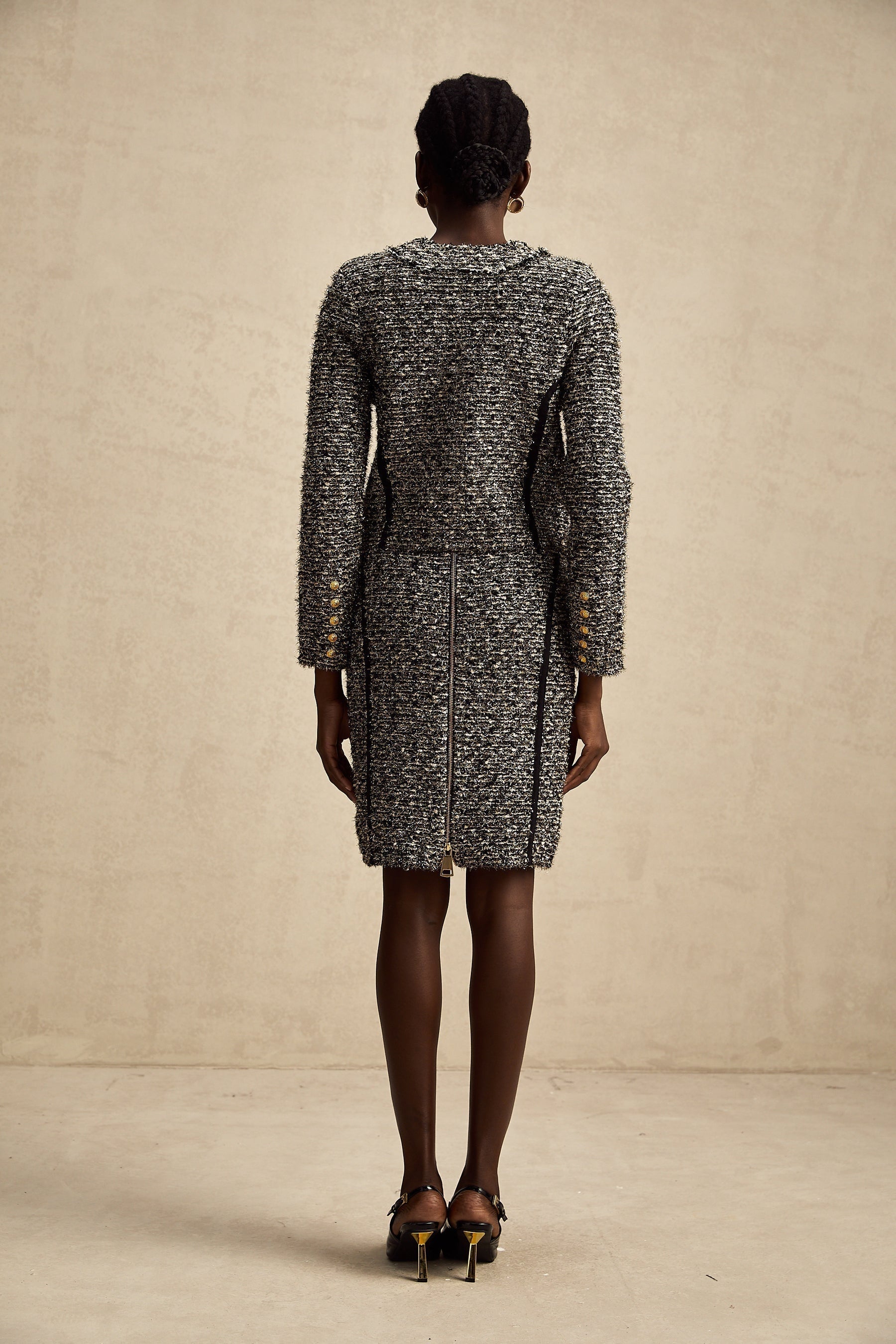 Woman wearing matching jacket and skirt set with contrasting colors and shimmering lurex fabric