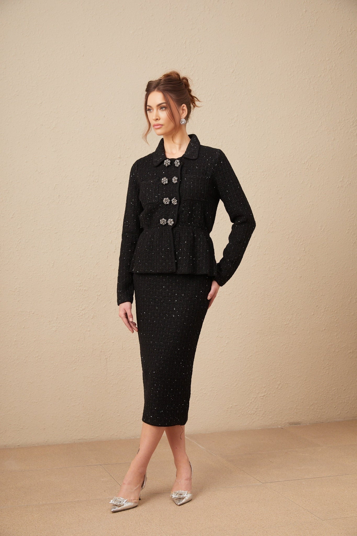 Woman wearing matching sequined waffle knit jacket and skirt set in shimmering fabric named Amina