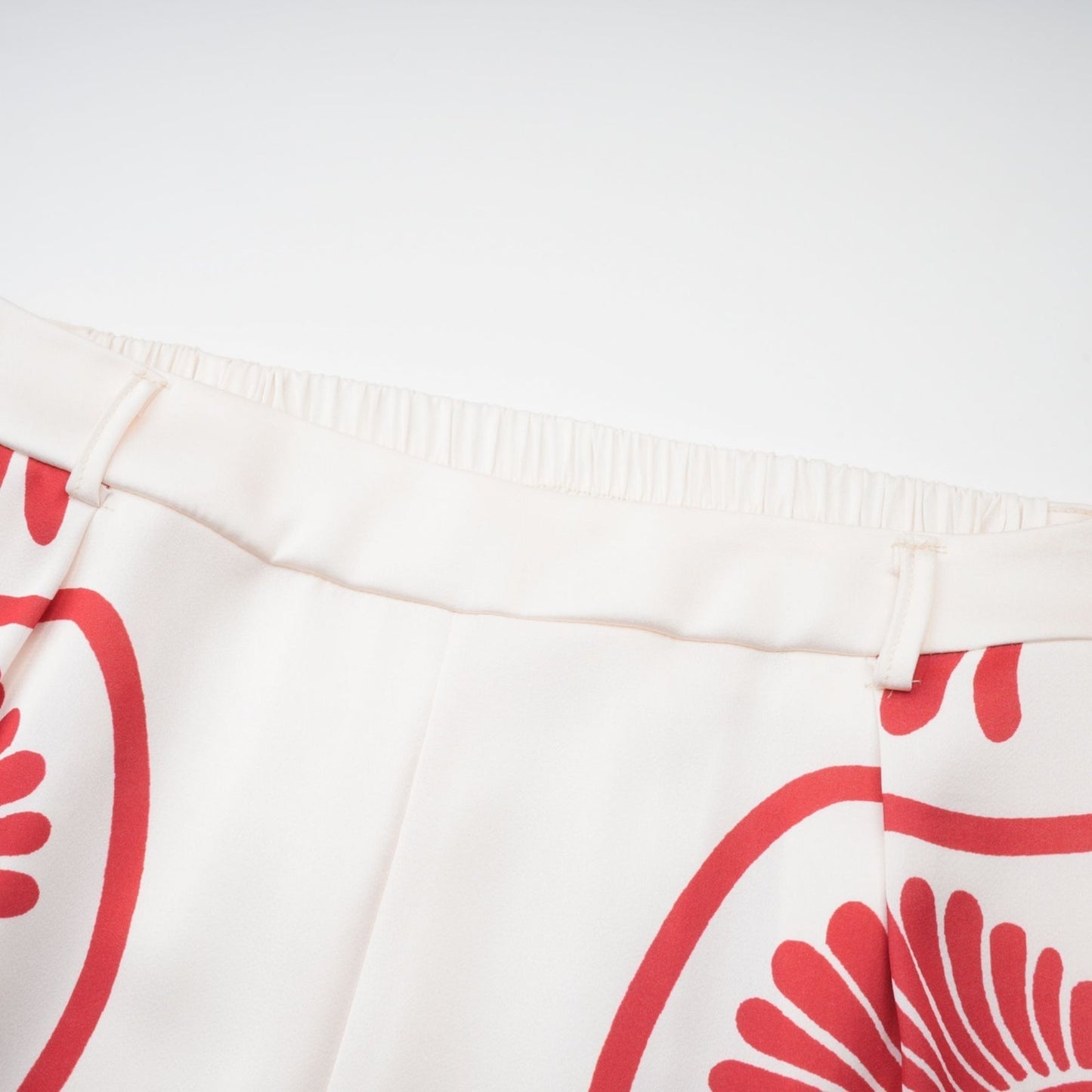 Woman wearing matching set with colorful graphic print shirt and trousers in vibrant Amaranta design